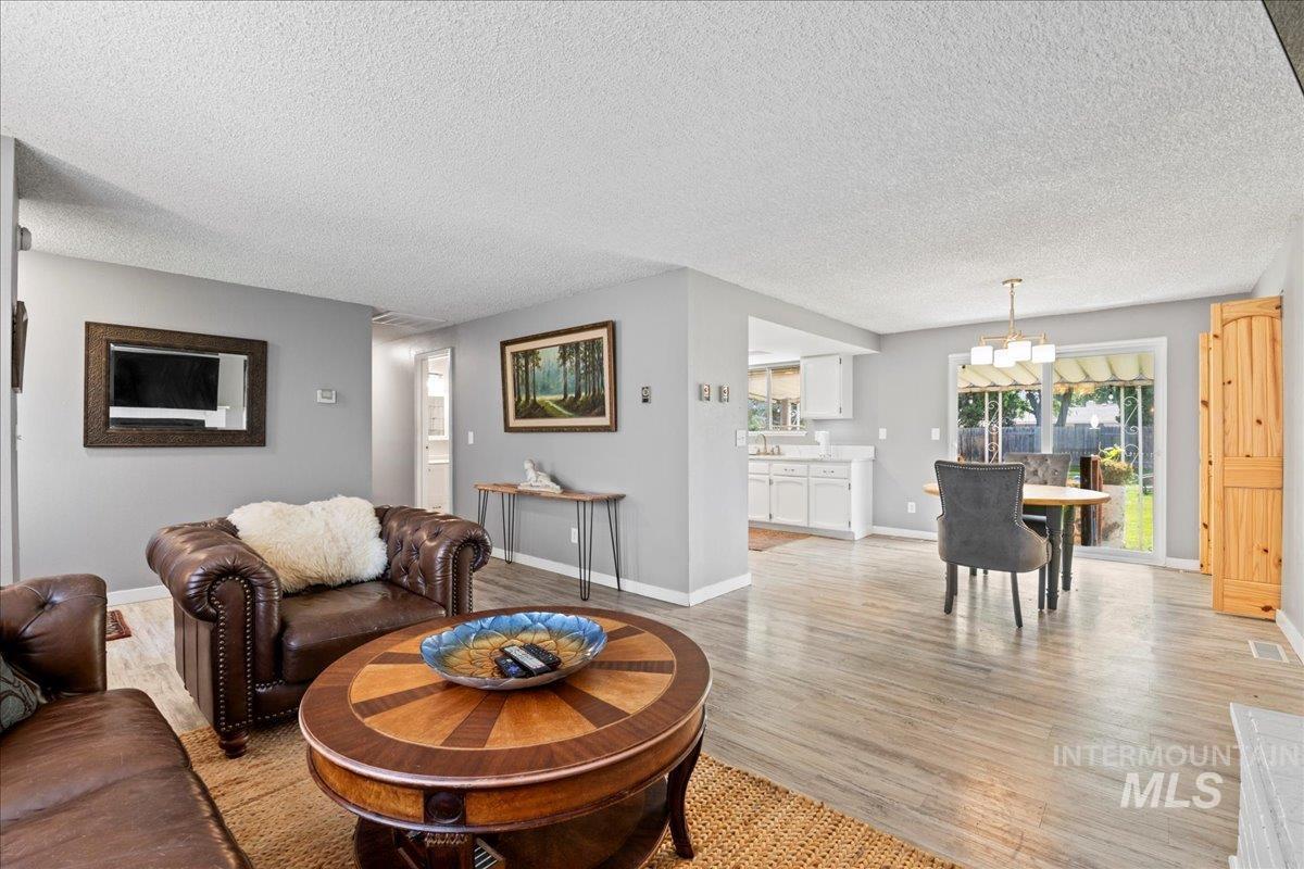 Living room with a textured ceiling and light wood-style flooring