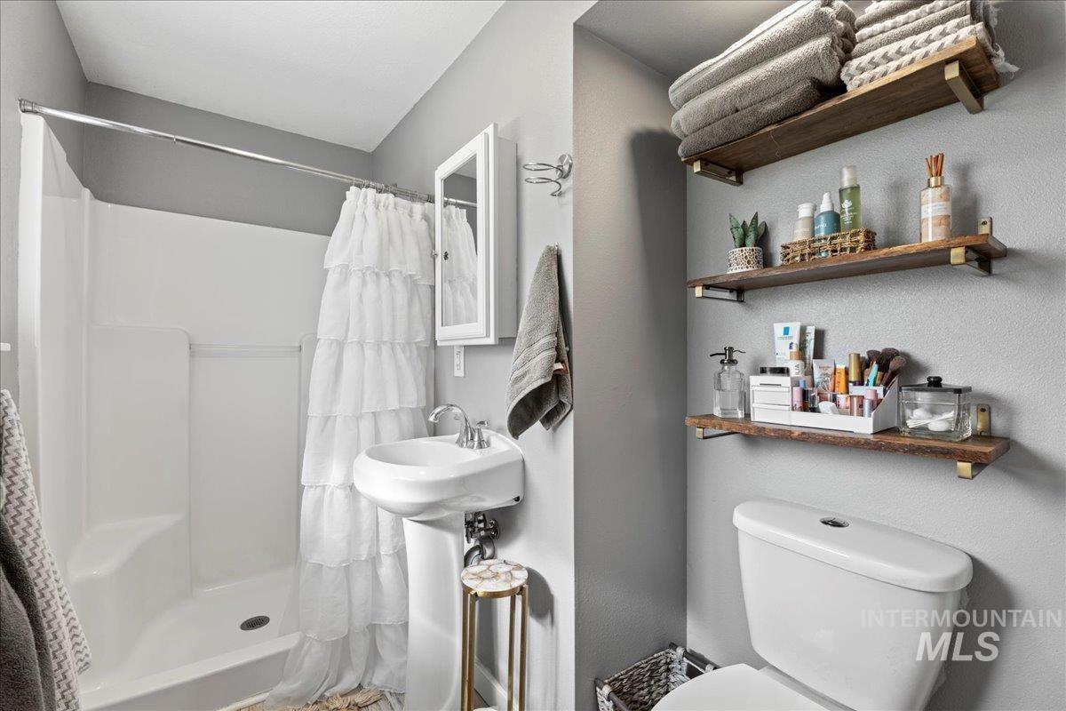 Full bath featuring toilet and a shower stall