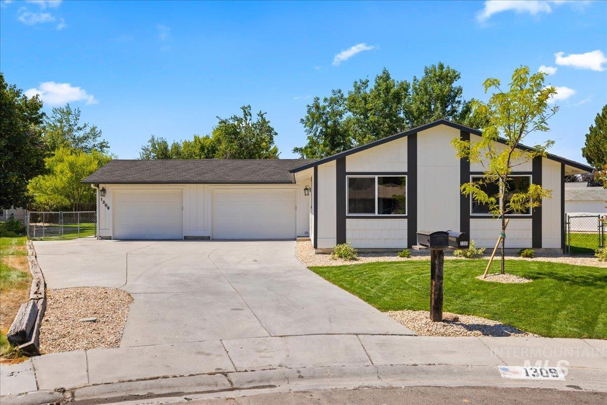 Single story home featuring a garage and driveway