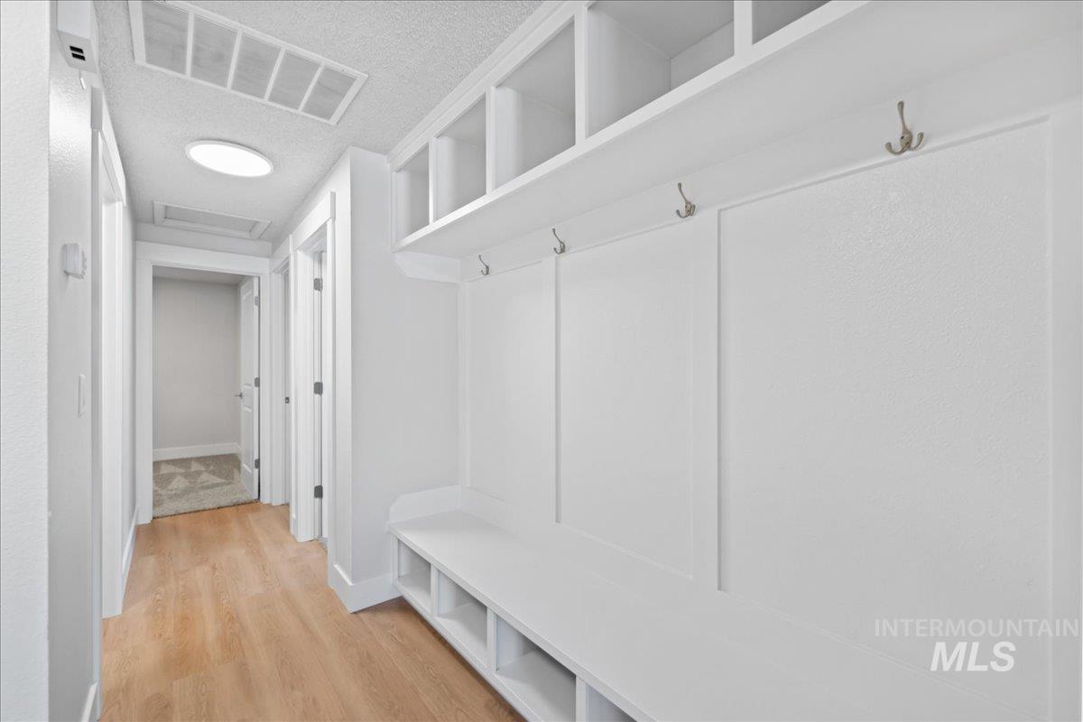 Mudroom featuring light wood-type flooring and a textured ceiling