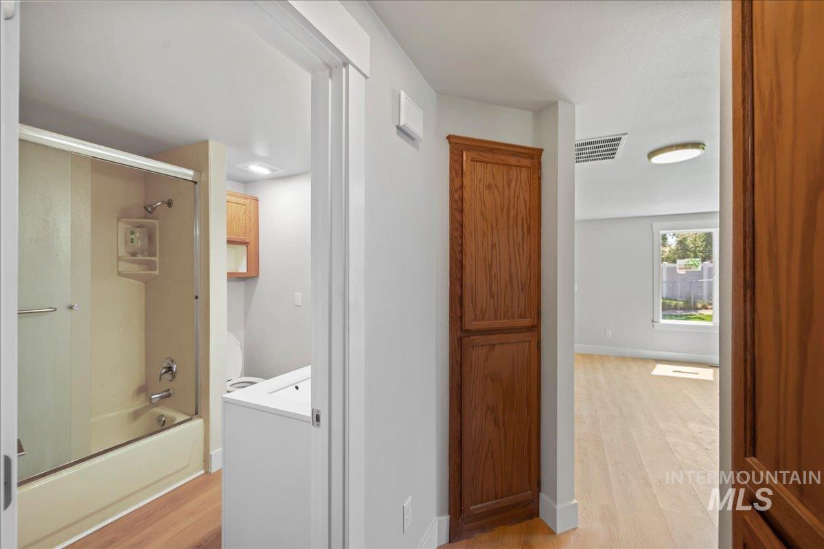 Hallway with light wood-type flooring and baseboards