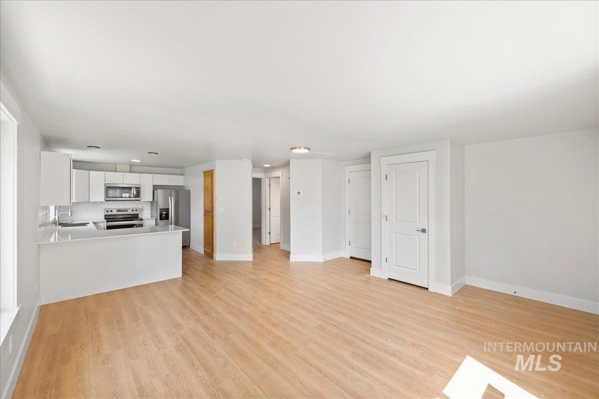 Unfurnished living room featuring light wood-style flooring and recessed lighting