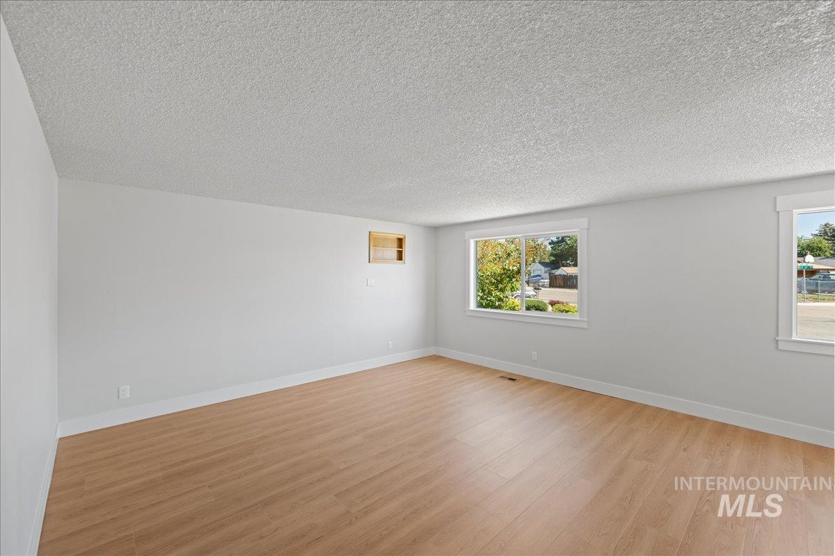 Spare room with light wood-style floors and a textured ceiling