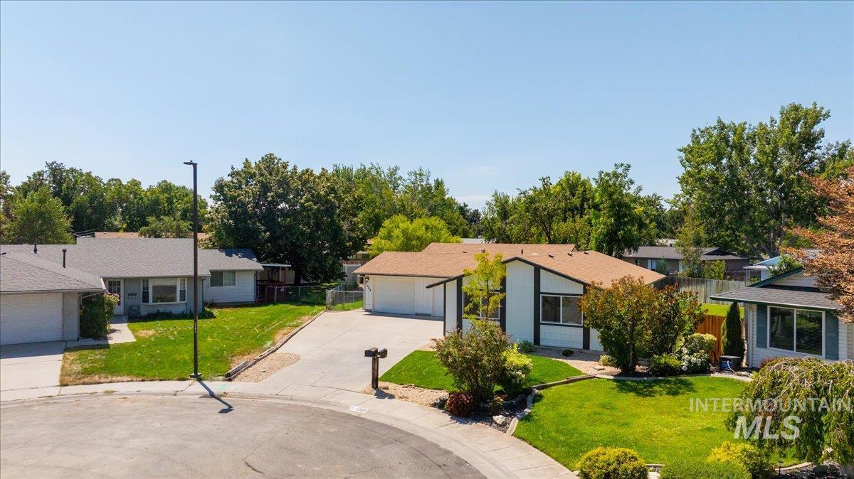View of front of house with a front yard, a garage, and driveway