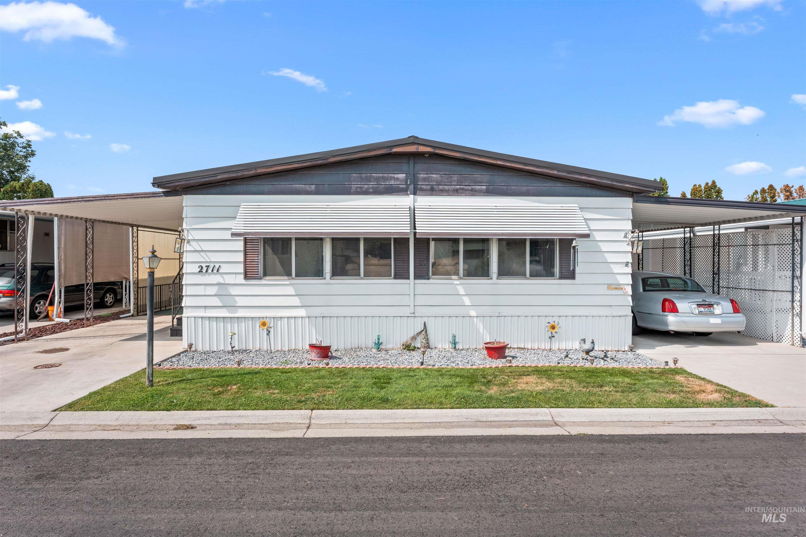 Manufactured / mobile home featuring a carport and concrete driveway