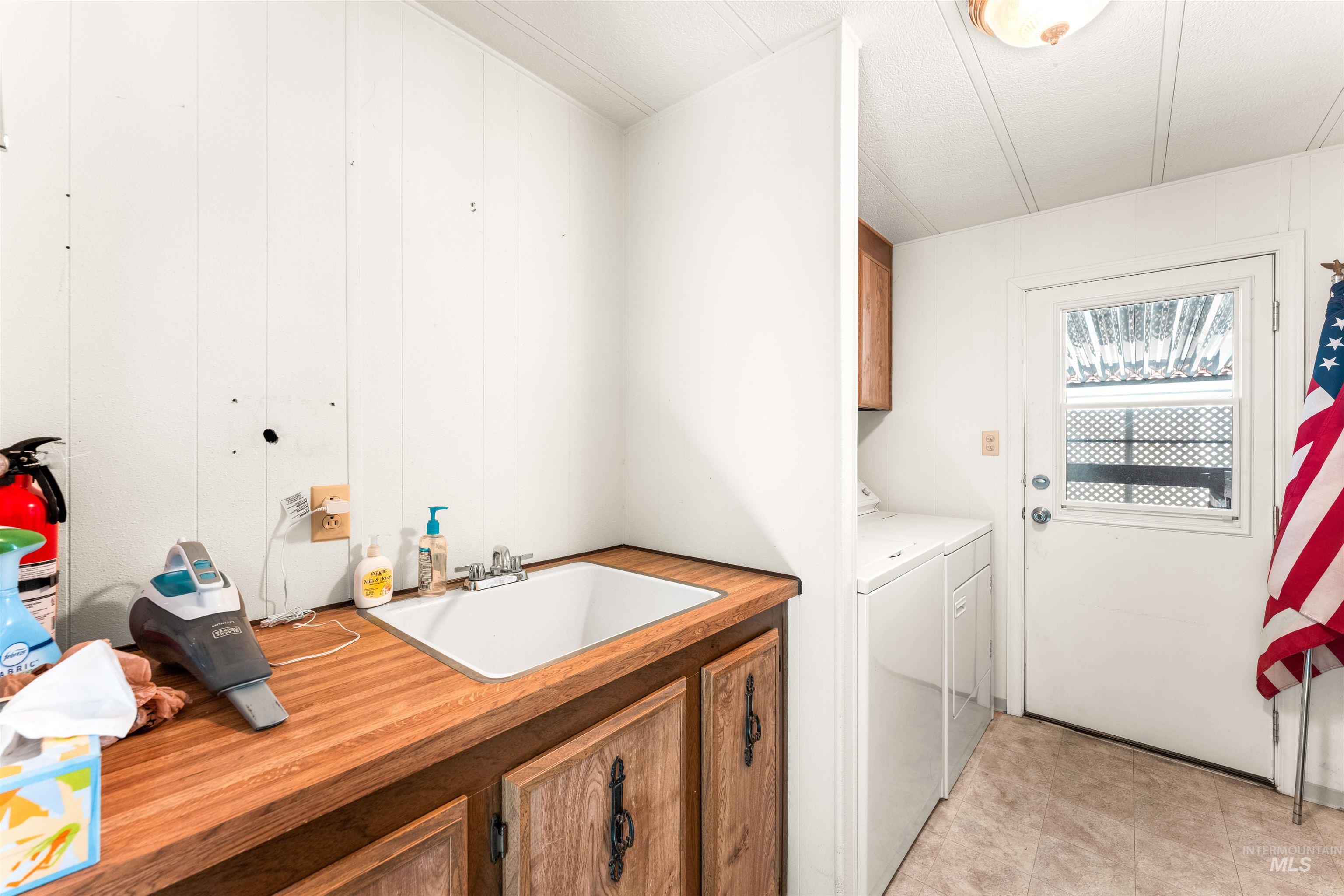 Washroom featuring cabinet space and washer and clothes dryer