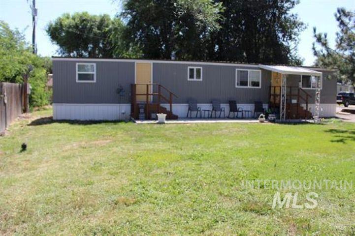 Manufactured / mobile home featuring a patio and a front lawn