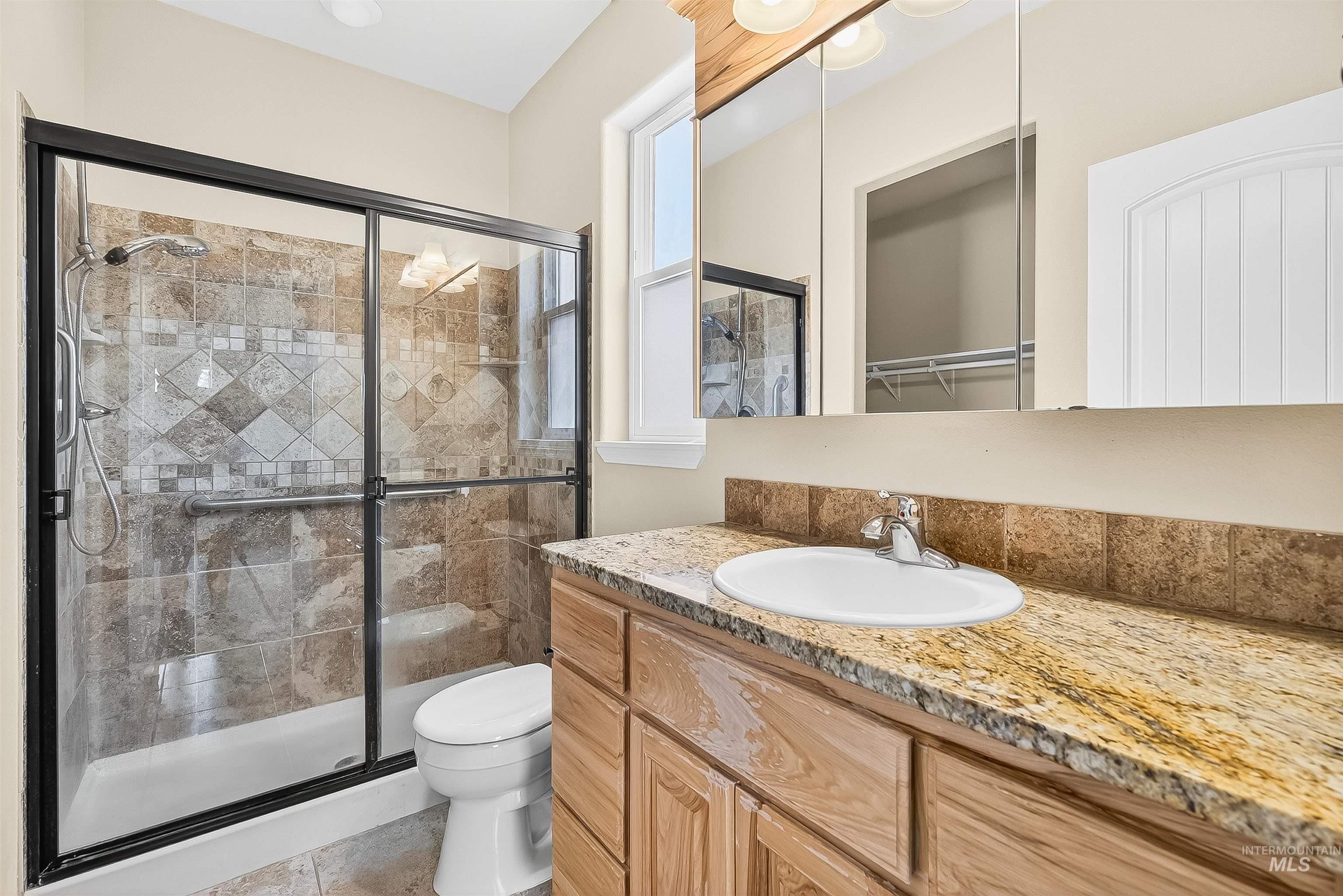 Bathroom with a stall shower, vanity, and light tile patterned floors