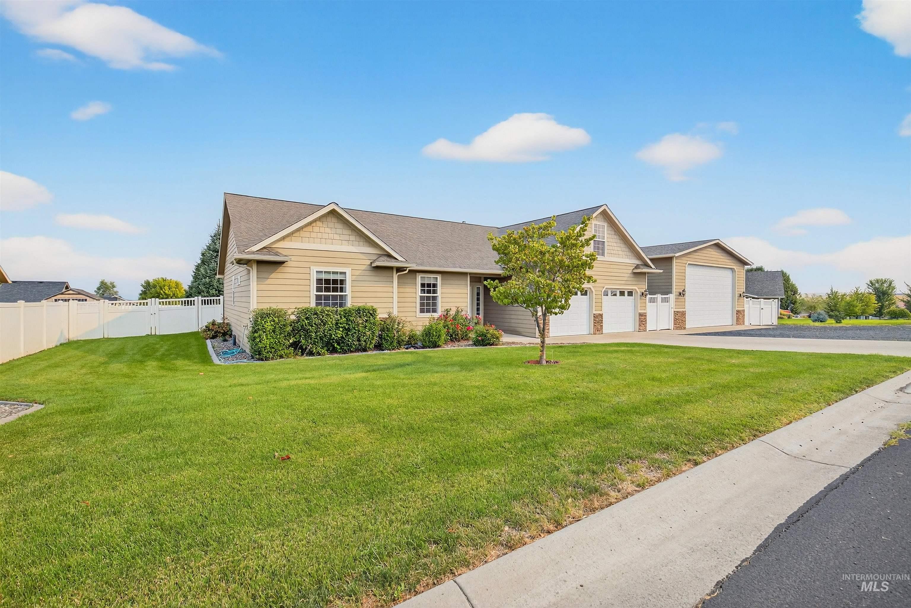 Ranch-style house featuring a shingled roof and asphalt driveway