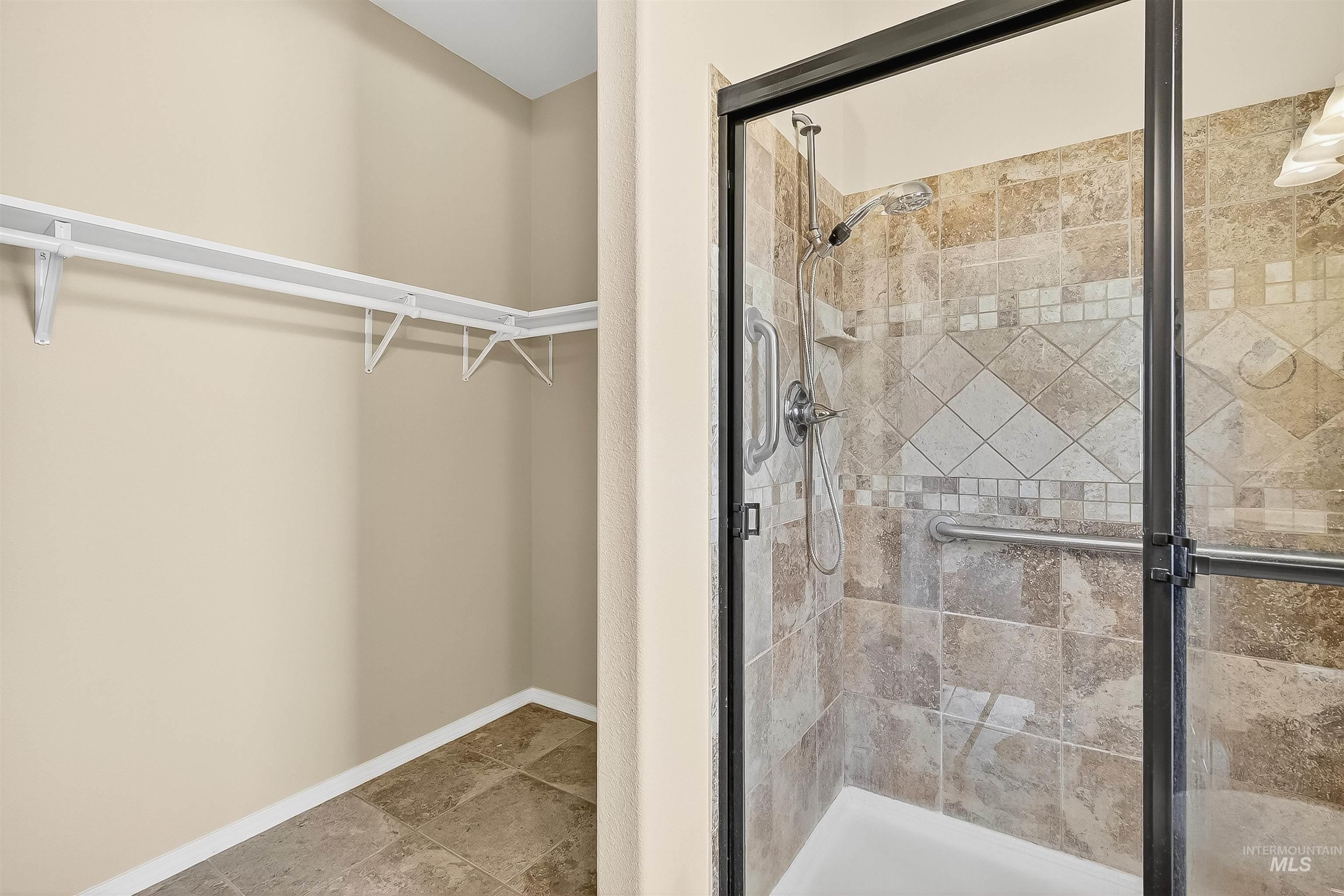 Full bath featuring a walk in closet and a stall shower