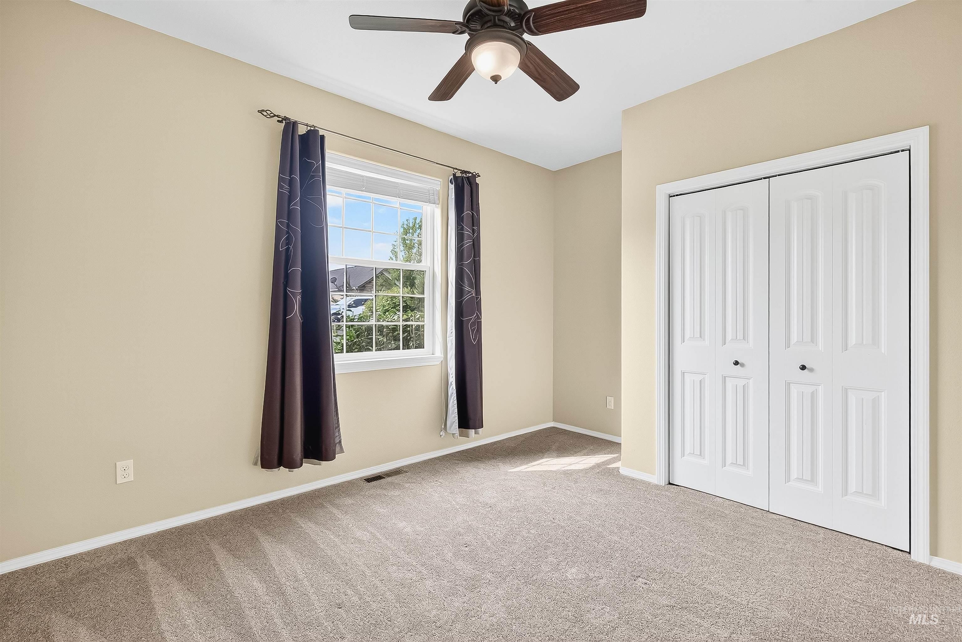Unfurnished bedroom with carpet floors, a closet, and a ceiling fan