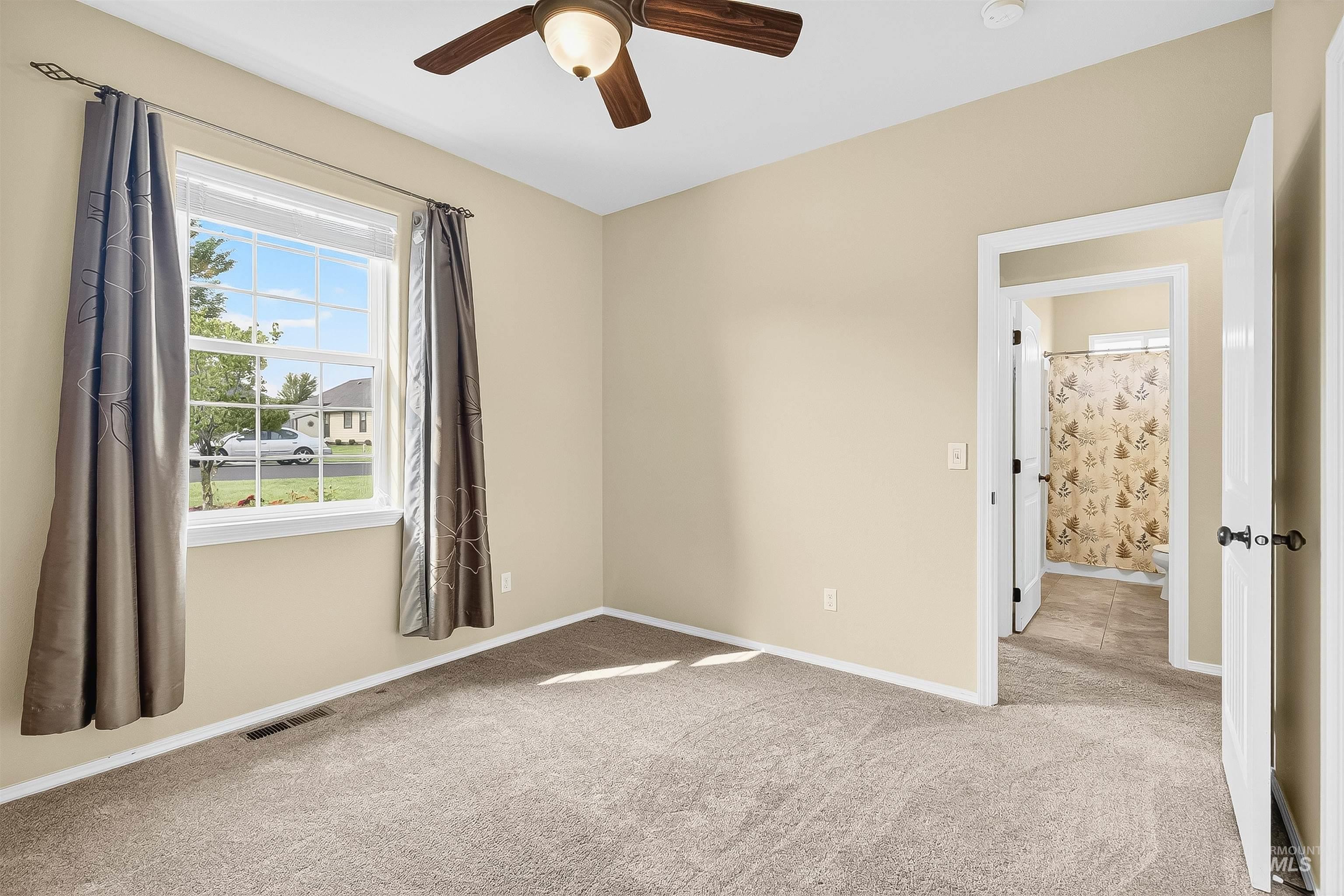 Empty room featuring light carpet and ceiling fan