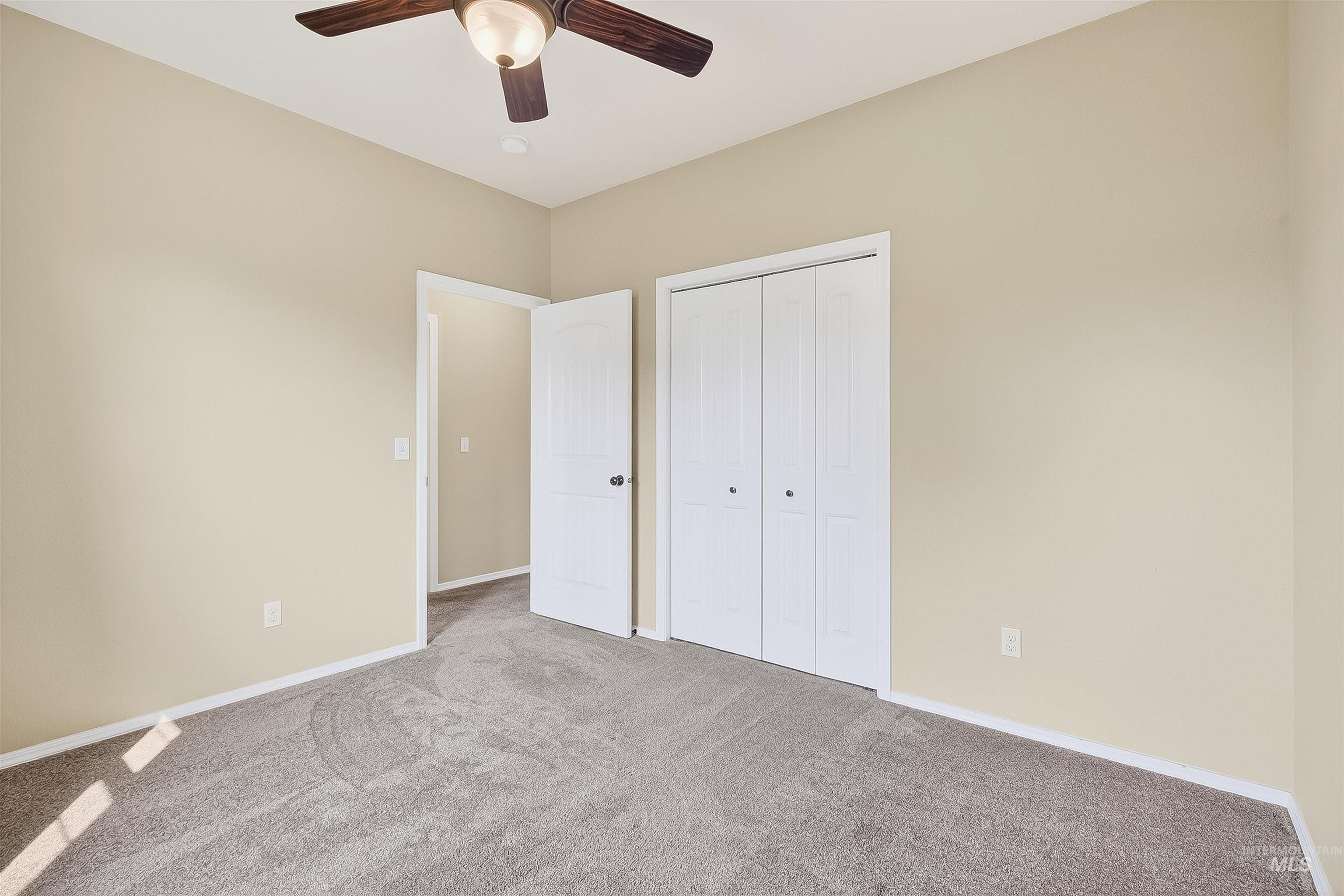 Unfurnished bedroom featuring carpet, a closet, and ceiling fan