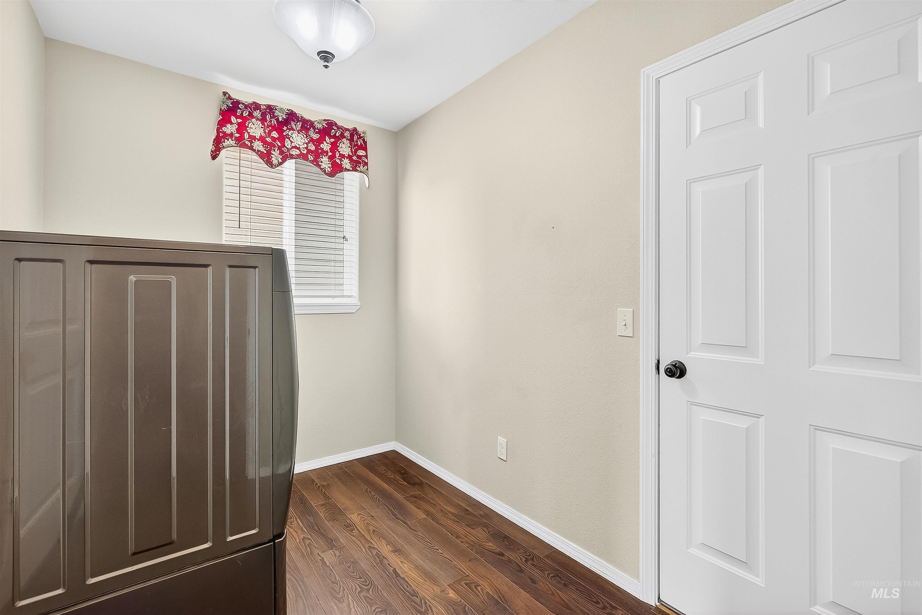 Unfurnished bedroom featuring baseboards and dark wood finished floors