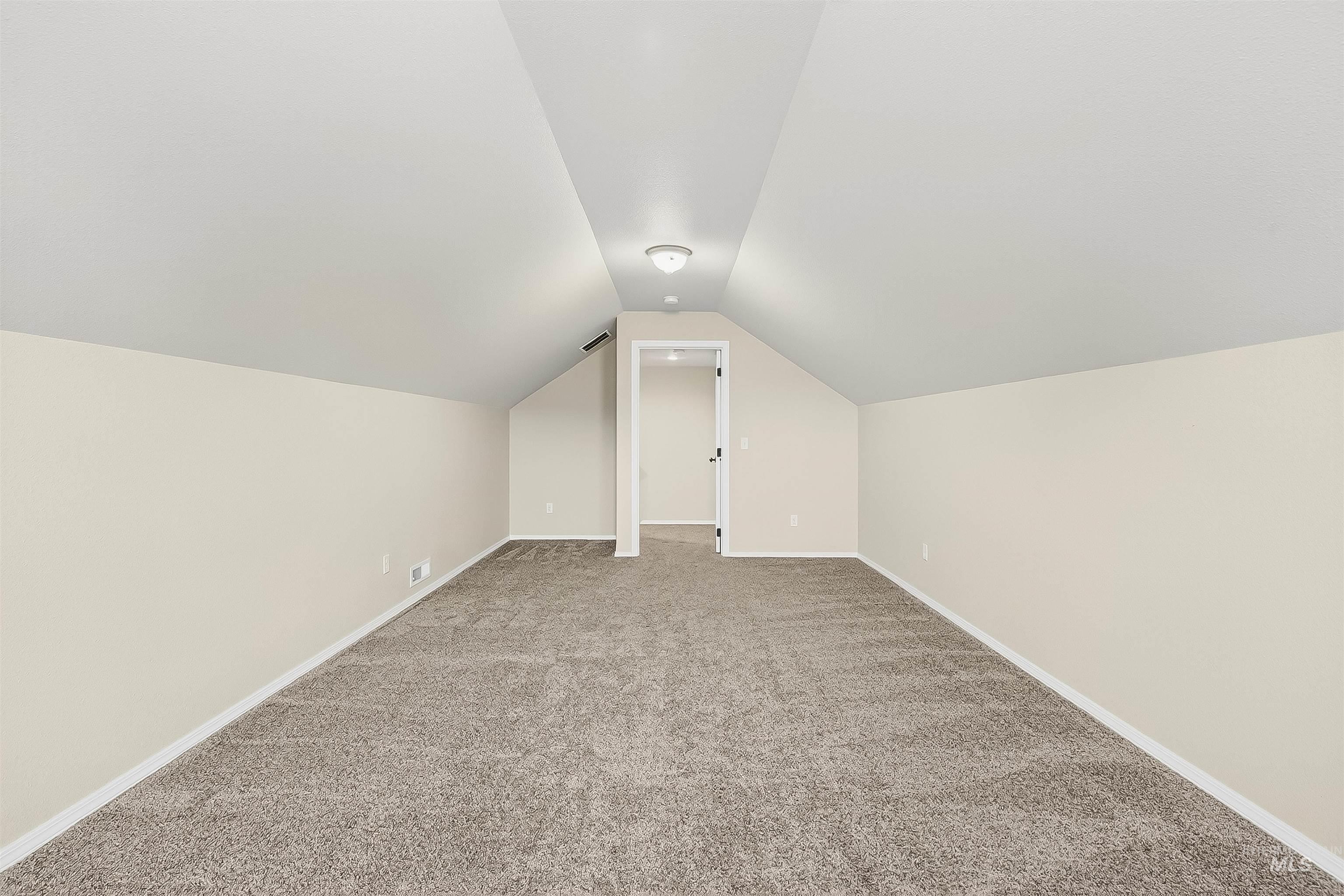 Bonus room featuring lofted ceiling and carpet flooring