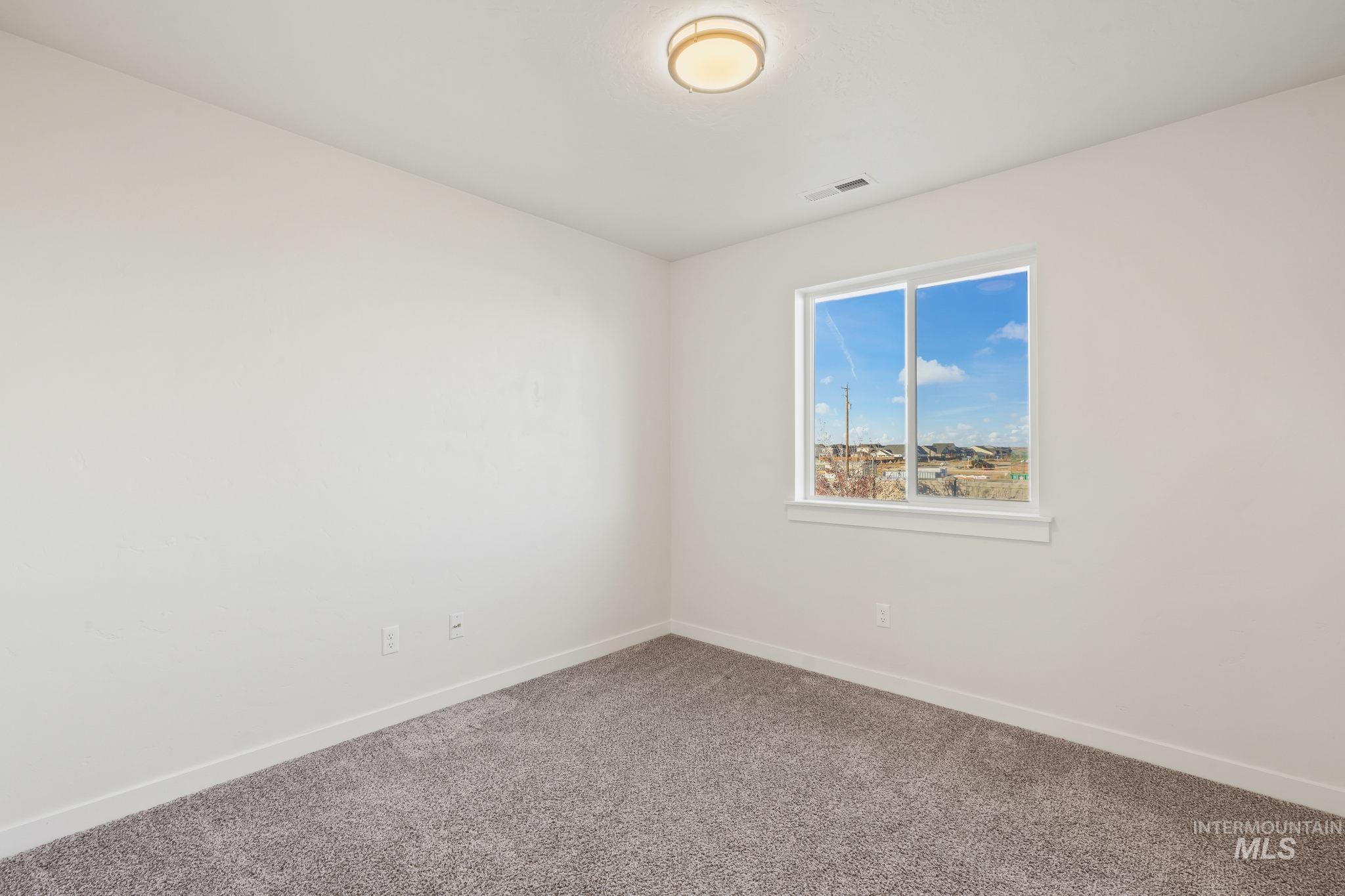 Carpeted empty room featuring baseboards