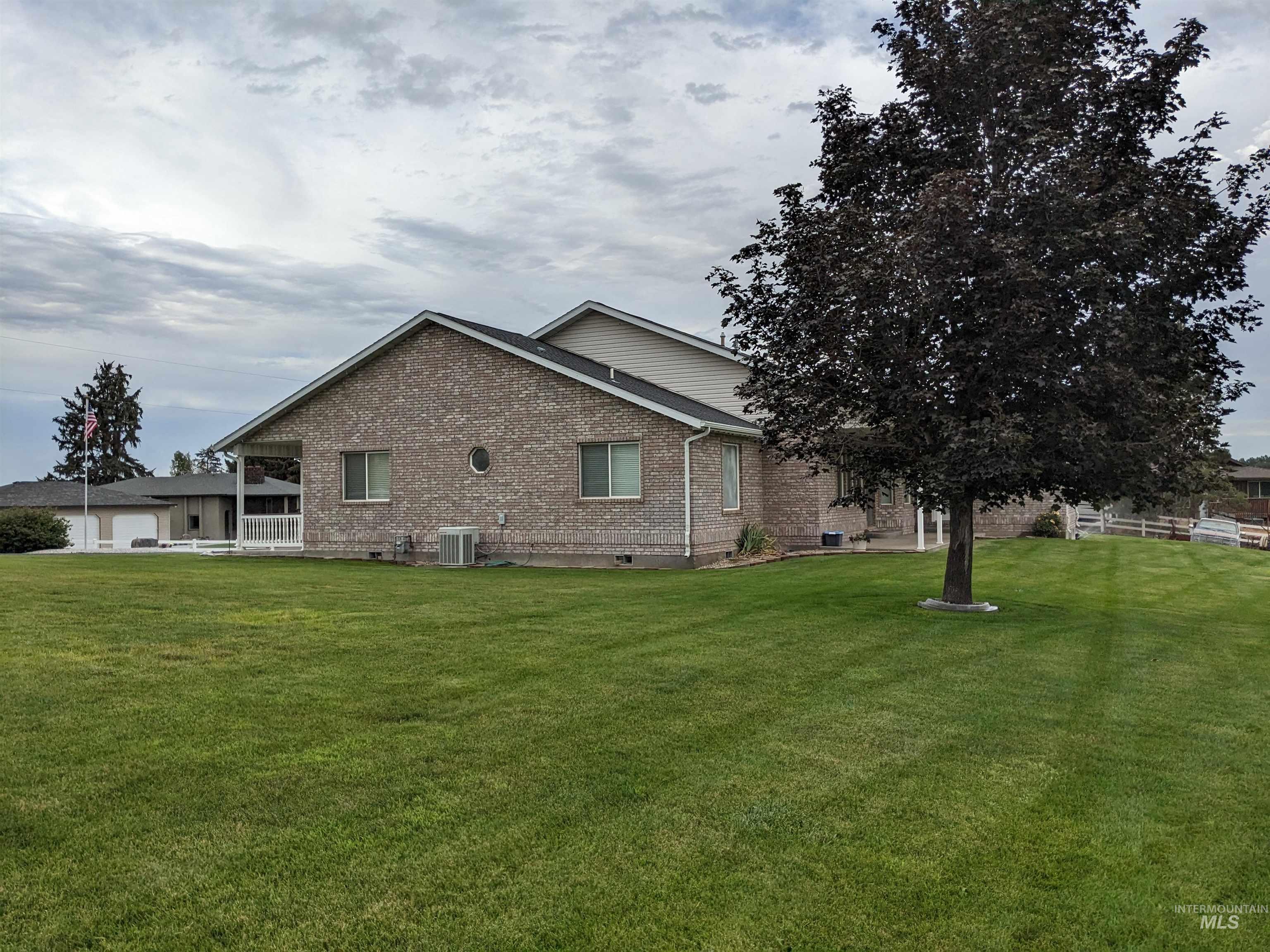 View of home's exterior with brick siding, a lawn, and crawl space