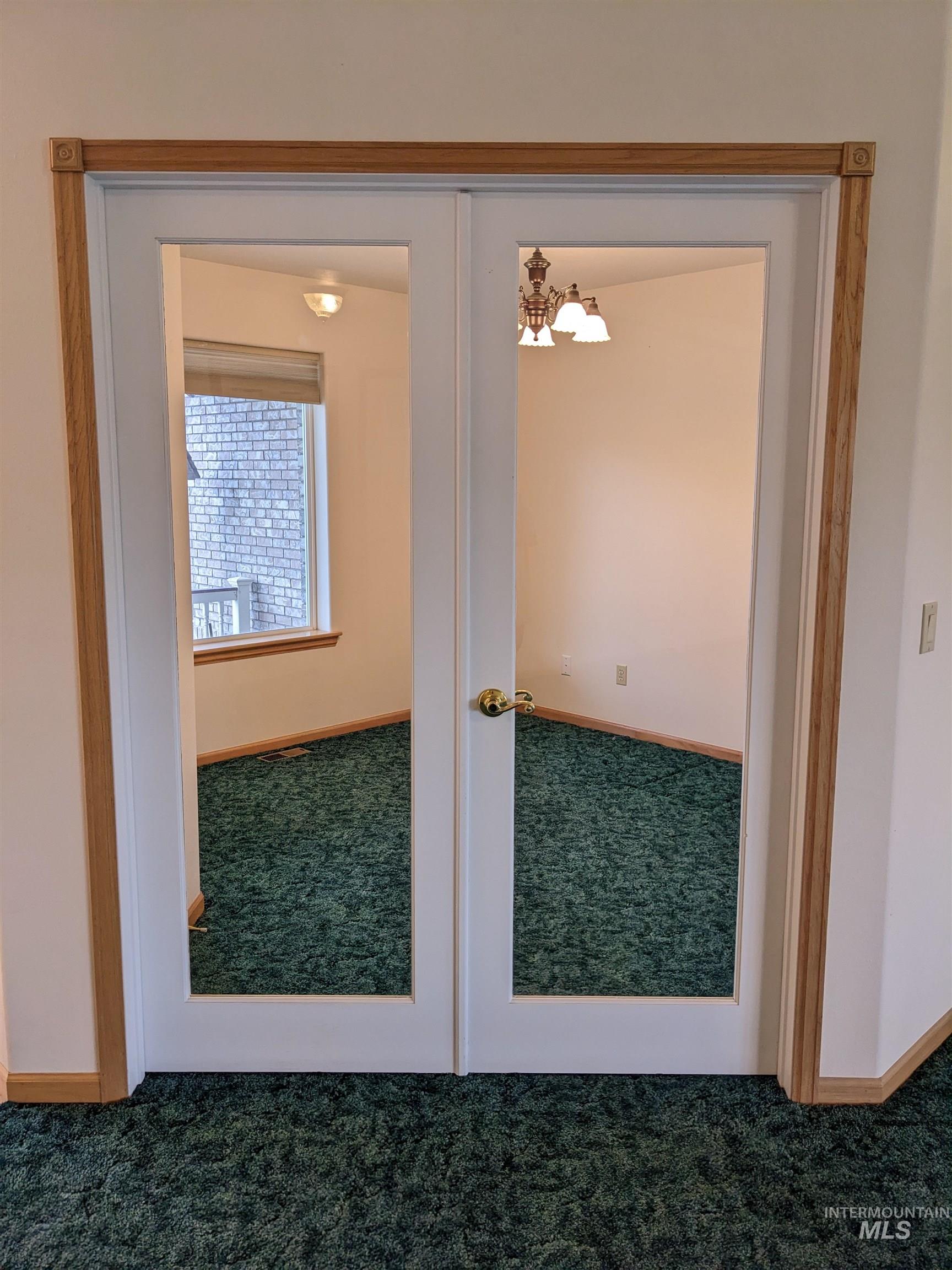 Doorway with carpet flooring and french doors
