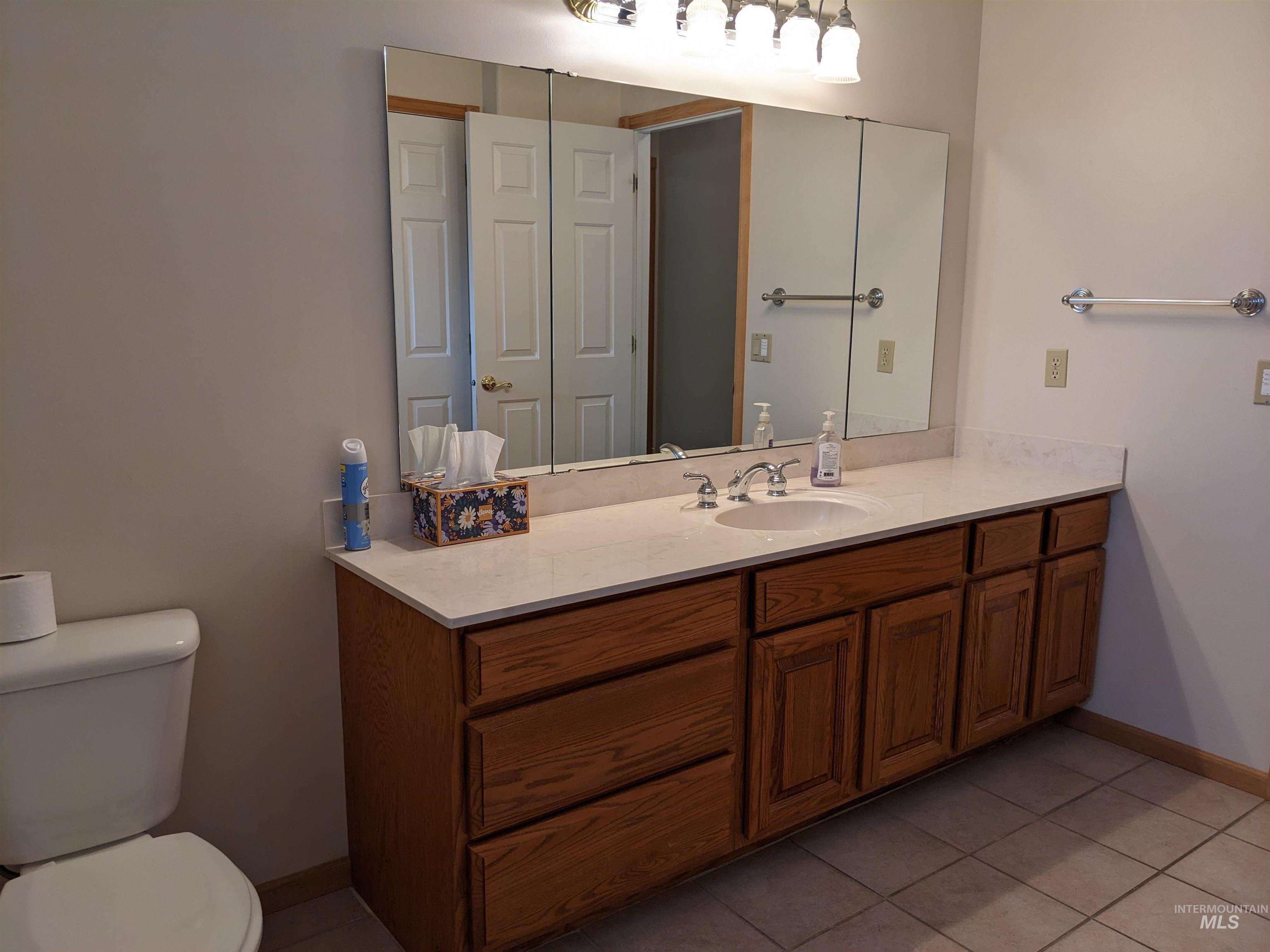Bathroom with light tile patterned floors and vanity
