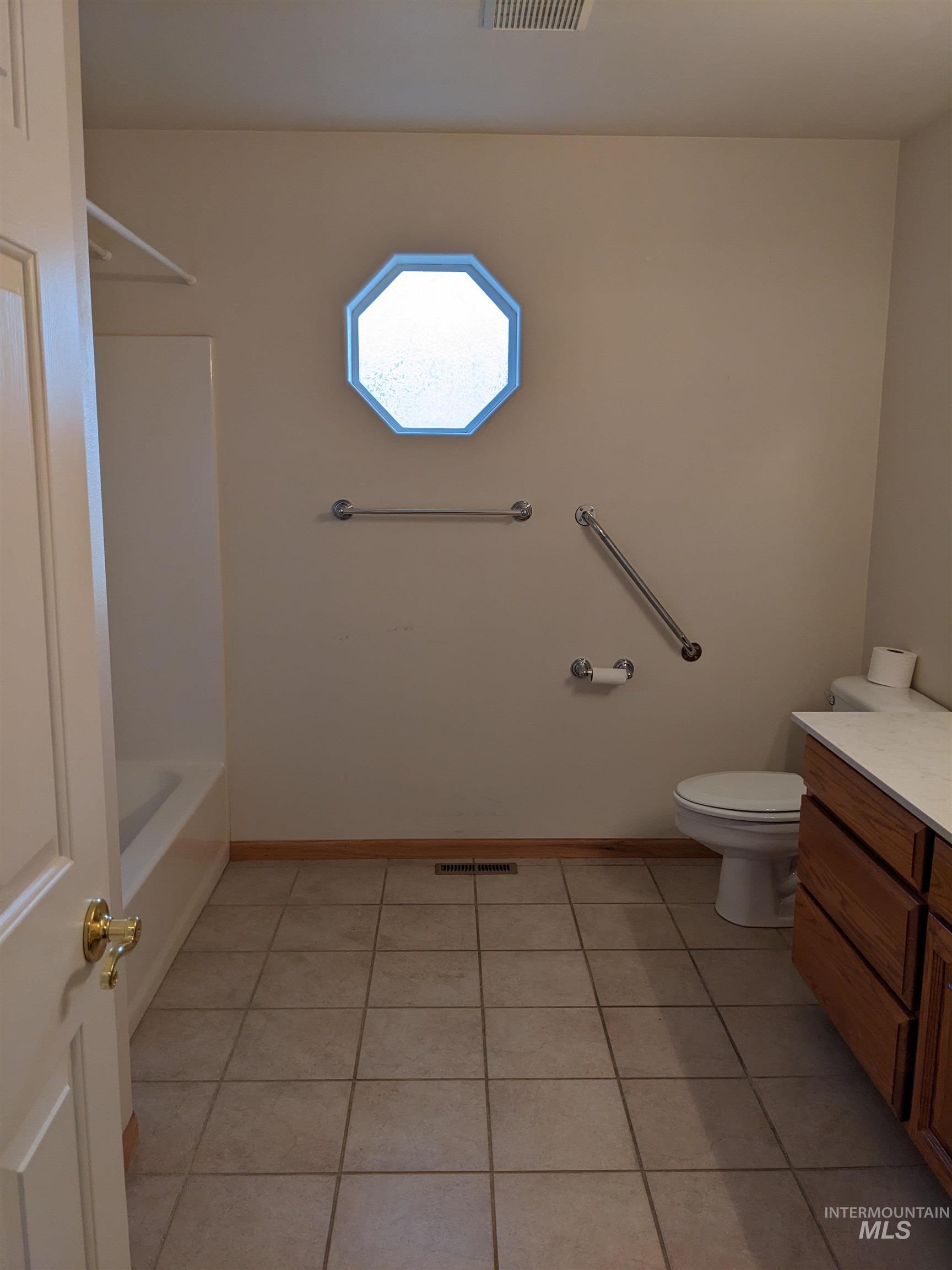 Full bathroom with vanity, light tile patterned floors, and shower / tub combination