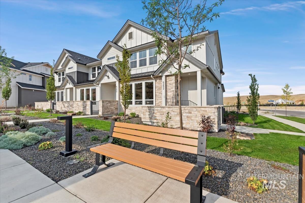 View of front of property featuring stone siding, board and batten siding, a standing seam roof, and a metal roof