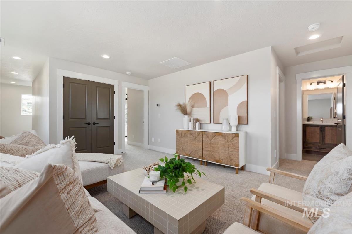 Carpeted living room featuring recessed lighting and baseboards