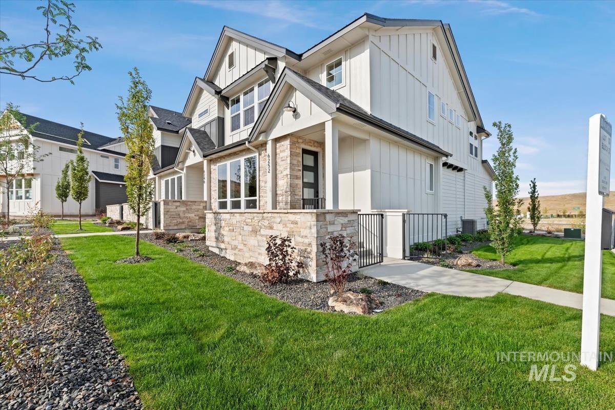 View of home's exterior featuring board and batten siding, a yard, and stone siding