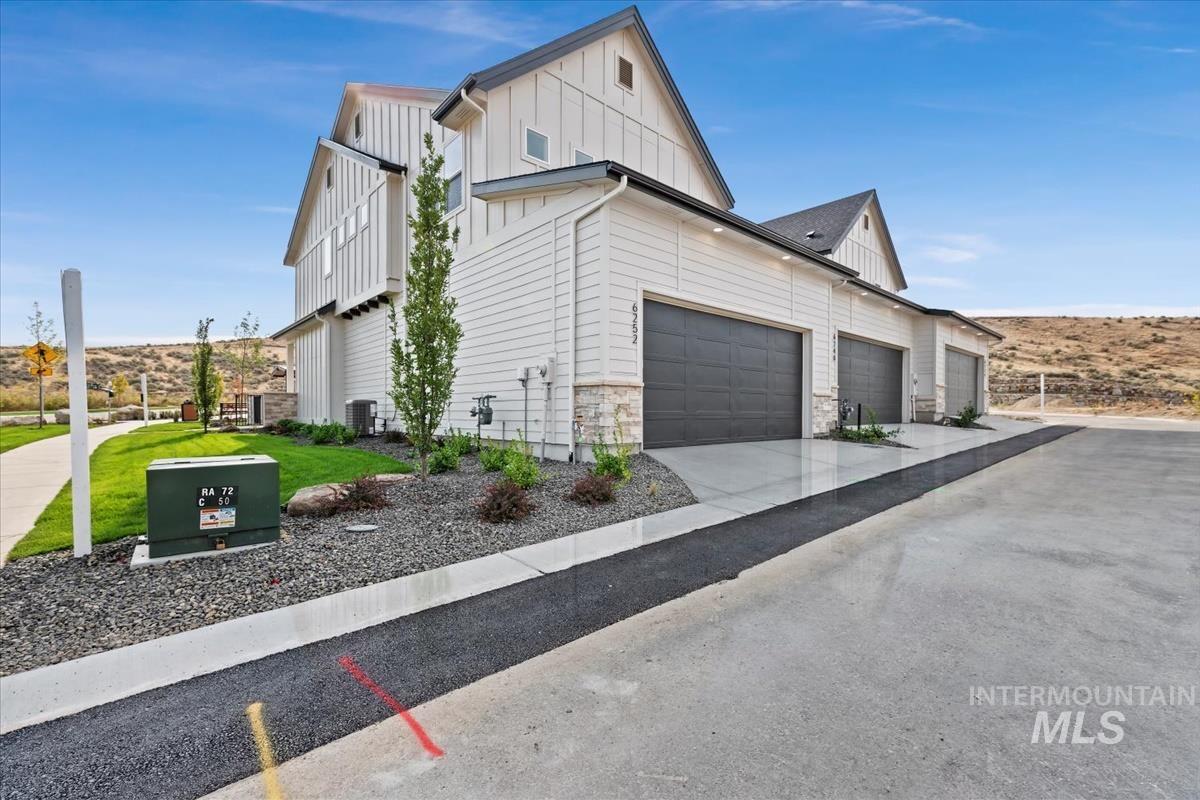 View of side of property featuring board and batten siding and driveway