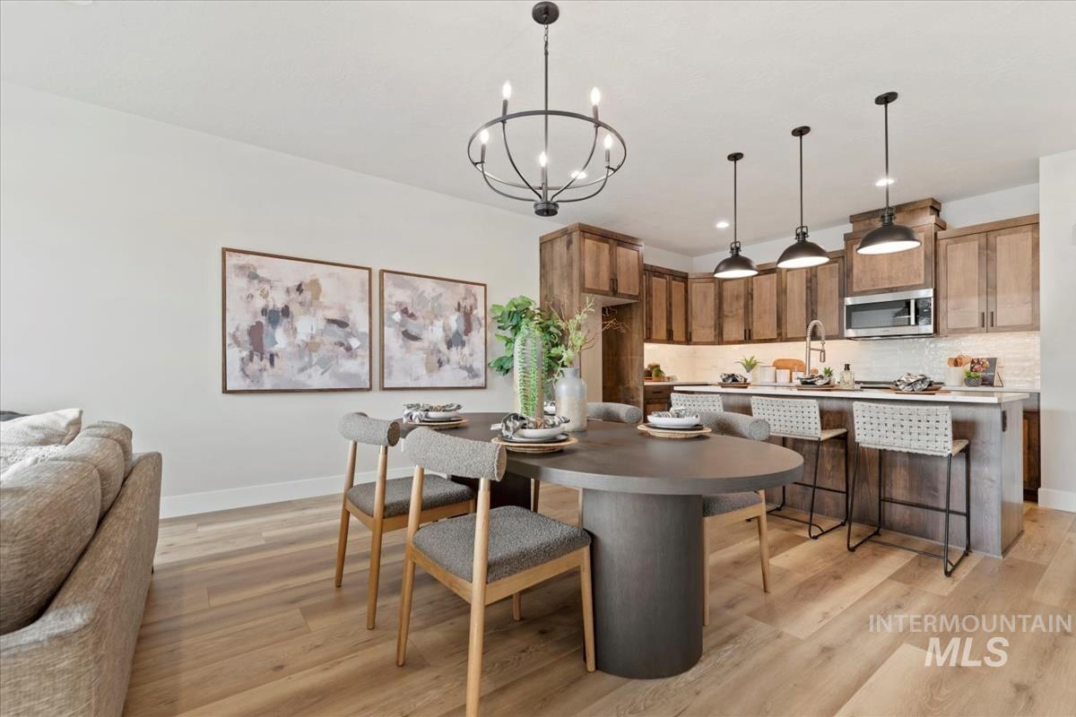 Dining room featuring light wood-style flooring, a chandelier, and recessed lighting