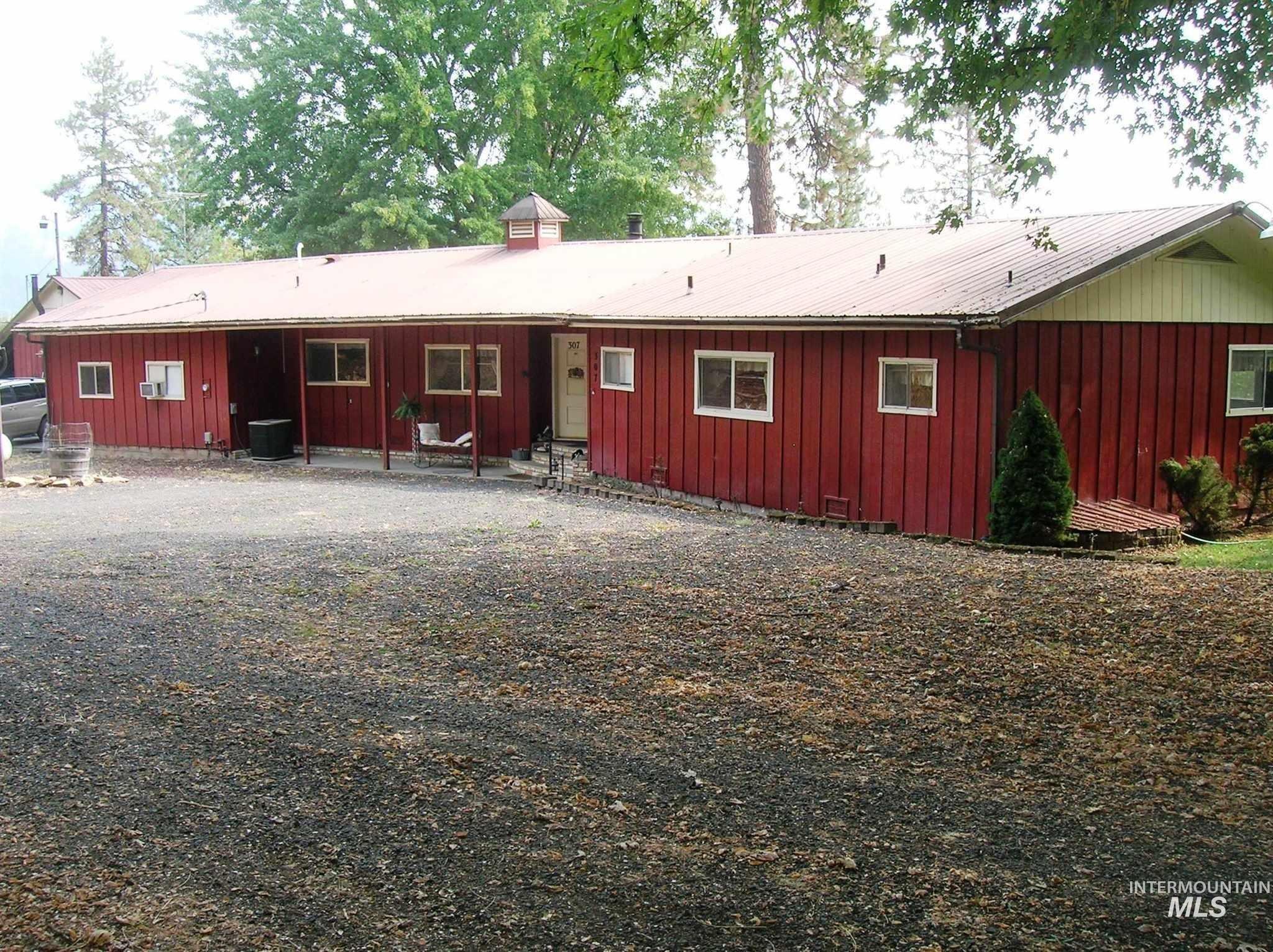 Rear view of house with board and batten siding, a metal roof, and a chimney