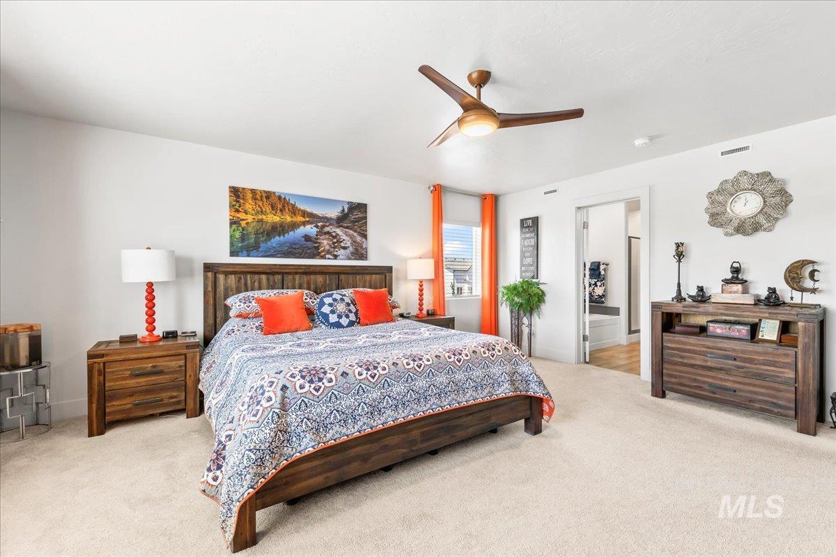 Carpeted bedroom featuring a ceiling fan