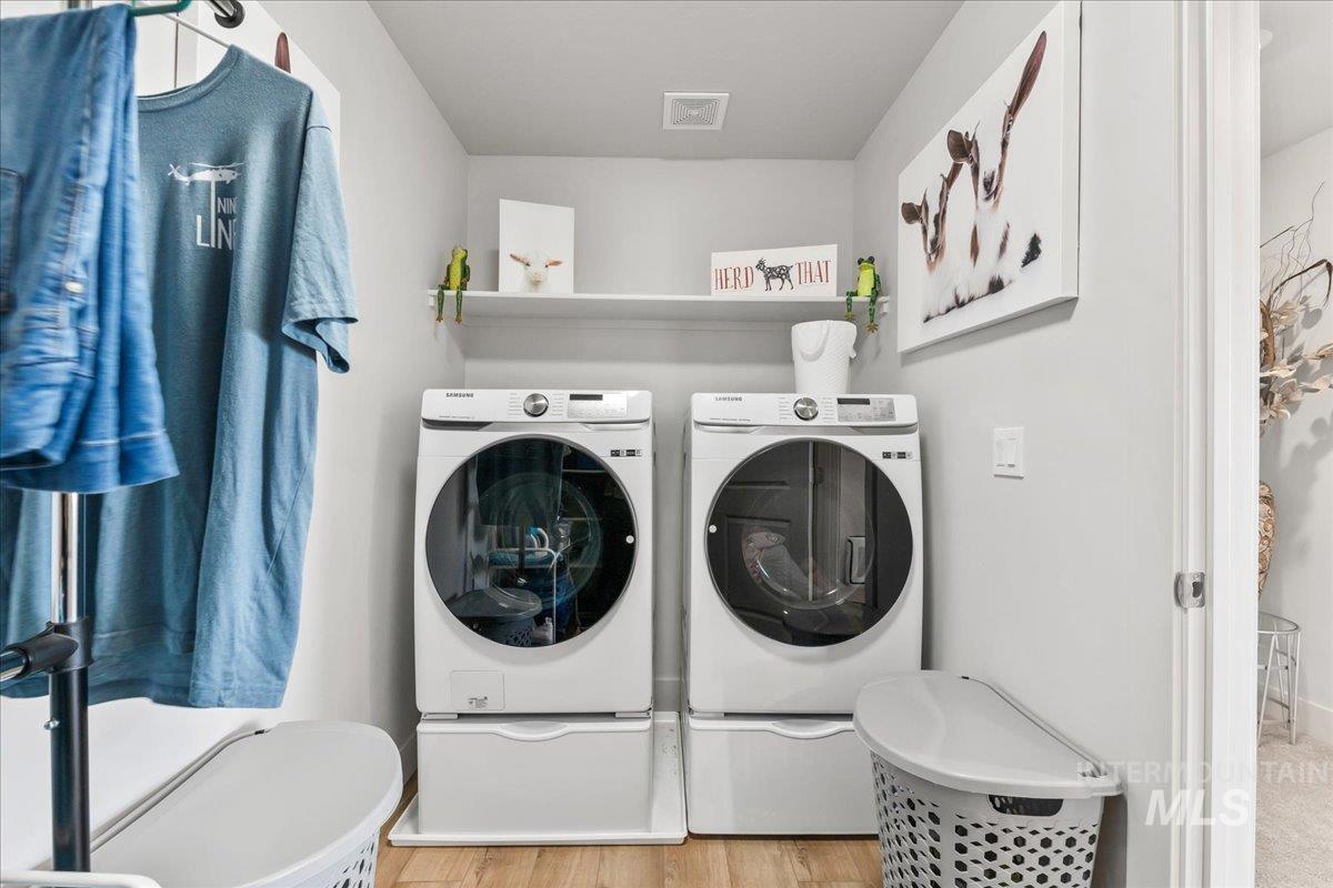 Washroom featuring light wood-style floors and independent washer and dryer