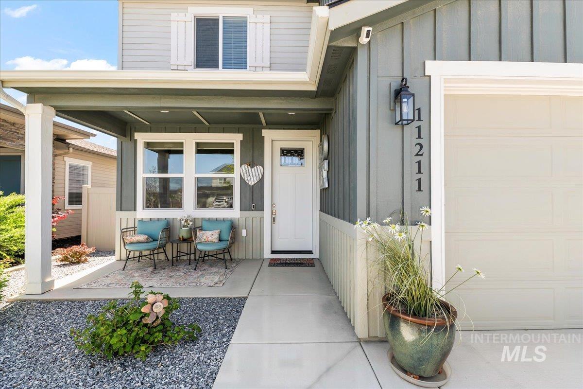 View of exterior entry featuring a porch, board and batten siding, and a garage