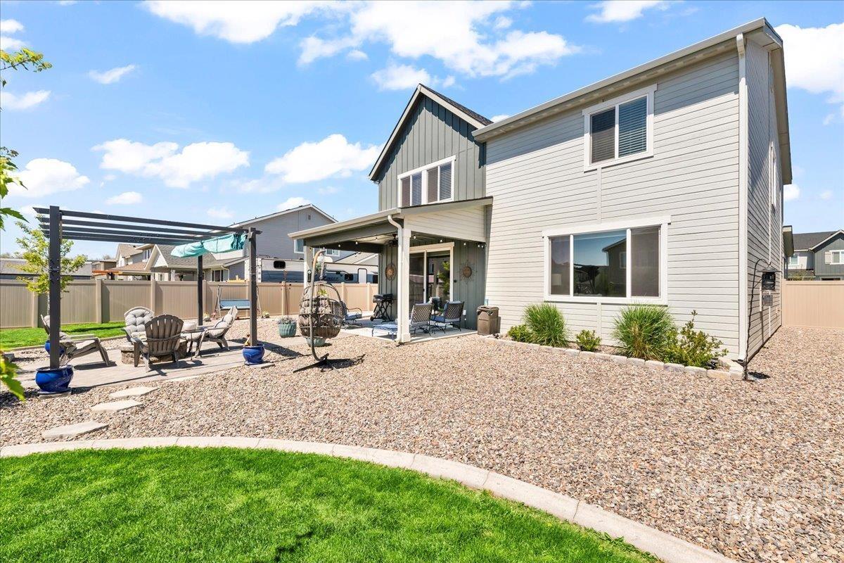 Back of property featuring a patio area, board and batten siding, and a fenced backyard