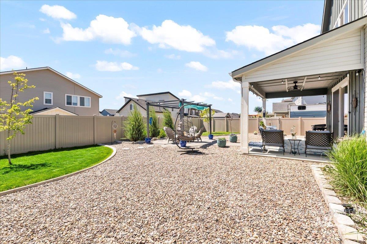 Fenced backyard with a patio and a ceiling fan