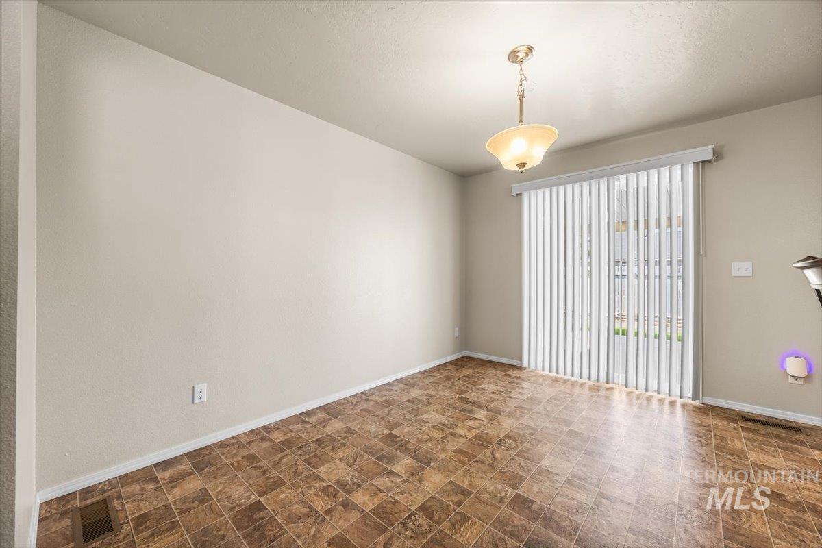 Unfurnished room with baseboards and stone finish flooring