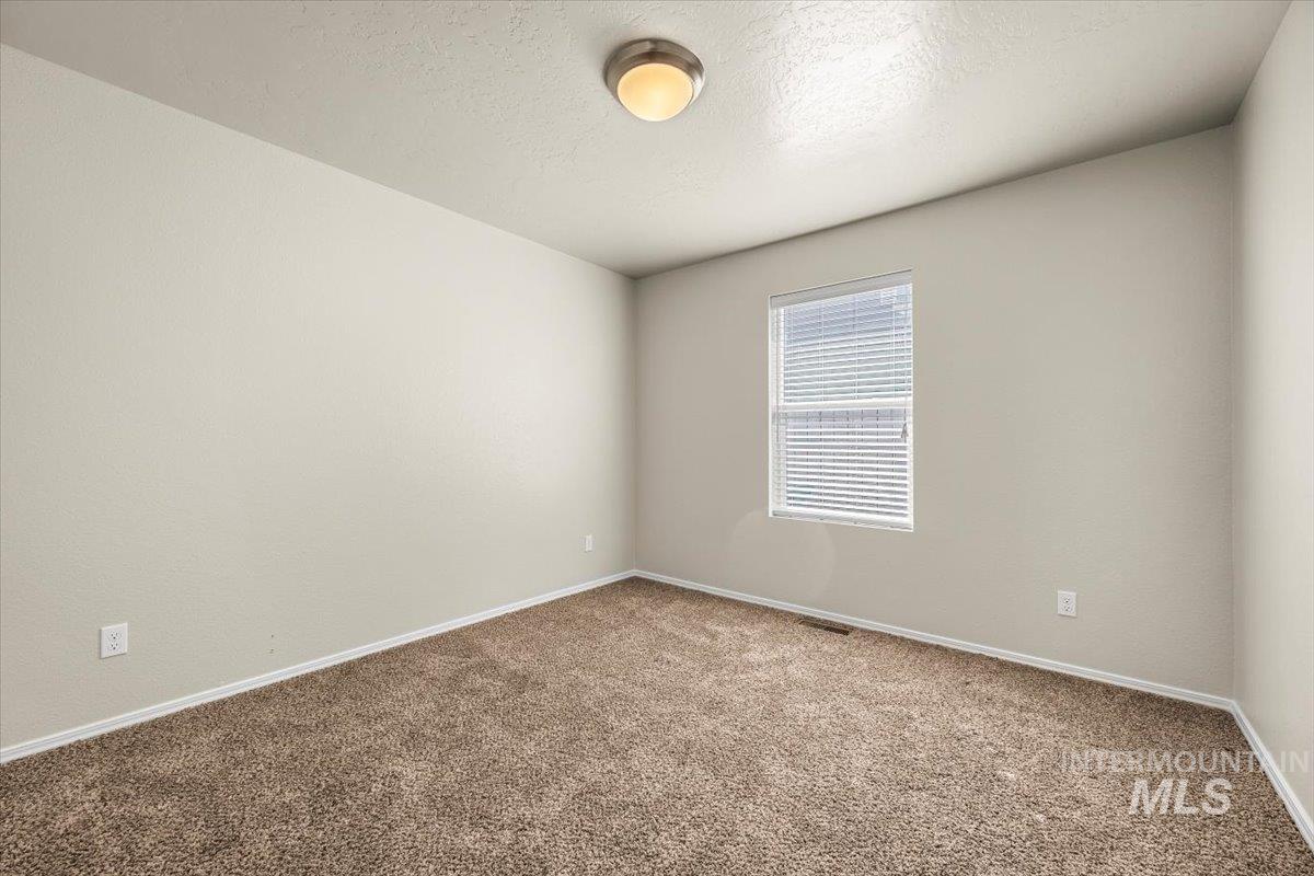 Unfurnished room featuring carpet floors and a textured ceiling