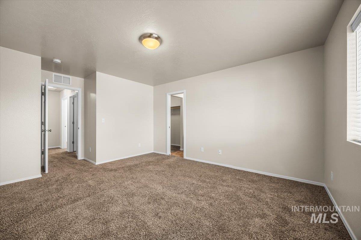 Spare room featuring dark colored carpet and a textured ceiling