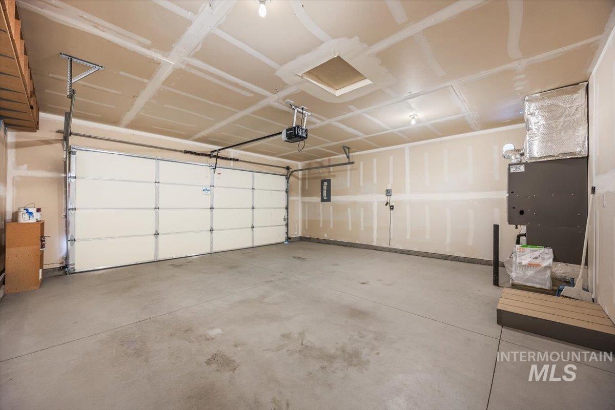Garage featuring heating unit and a garage door opener