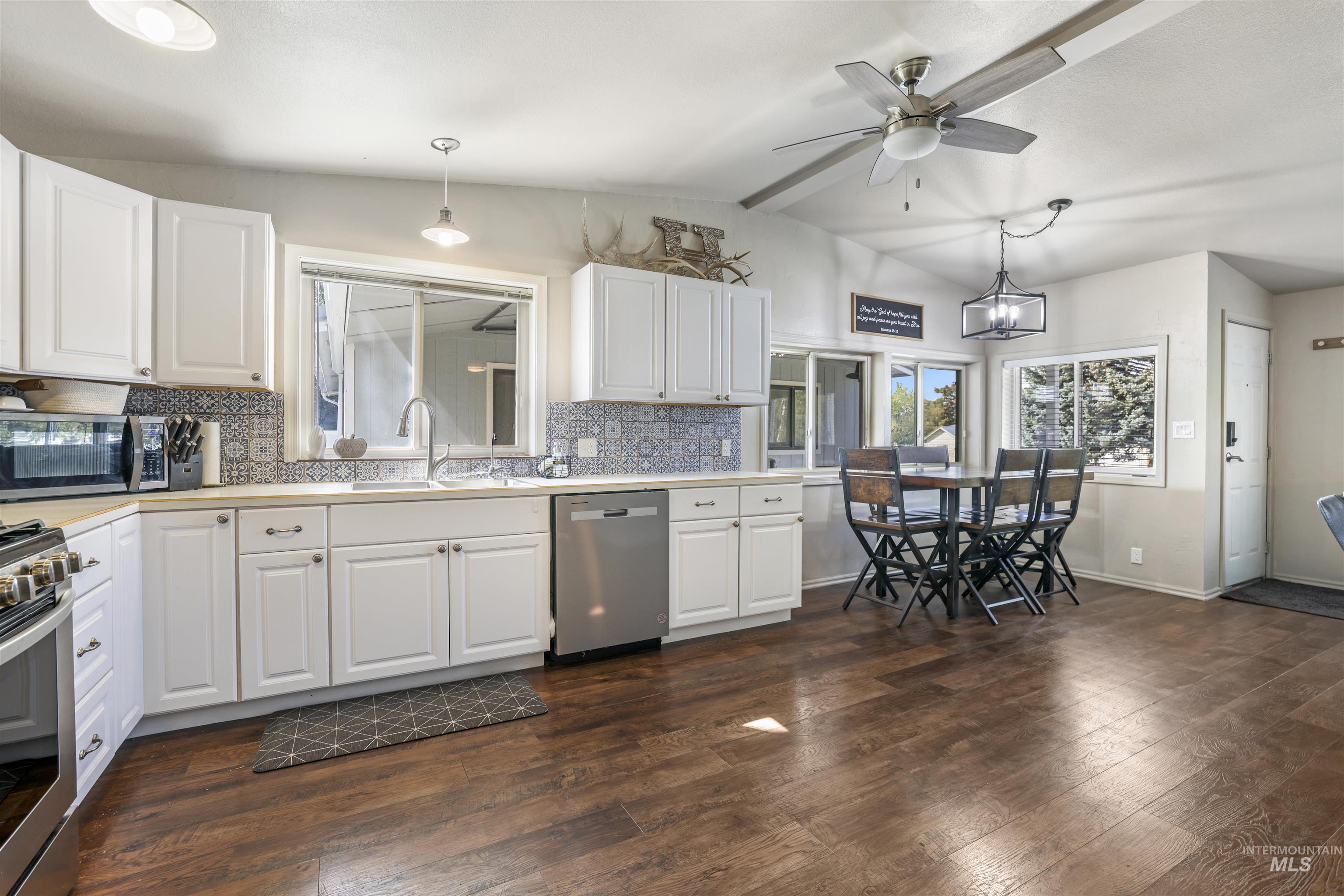Kitchen with light countertops, white cabinets, and vaulted ceiling