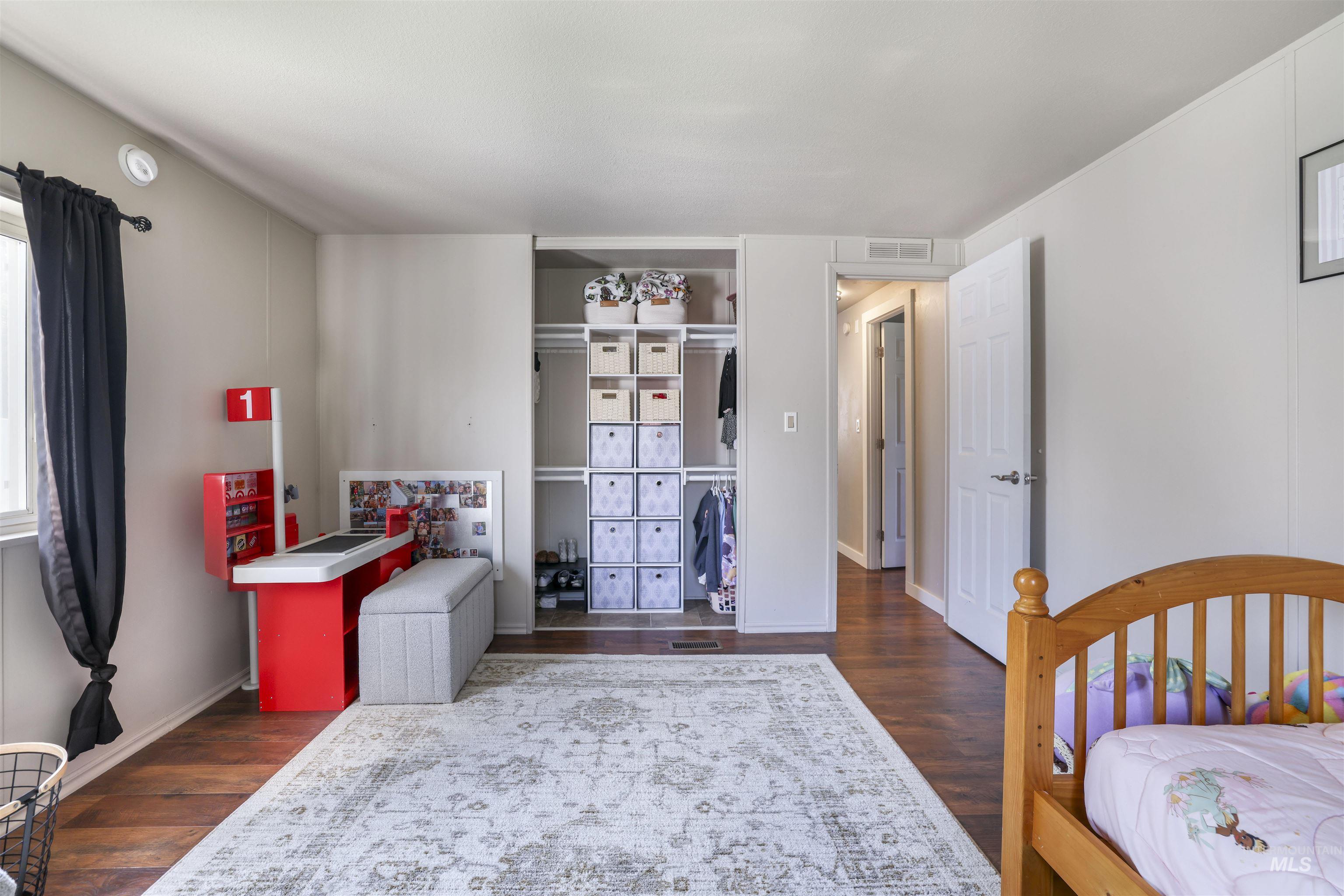 Bedroom featuring dark wood-style floors and a closet