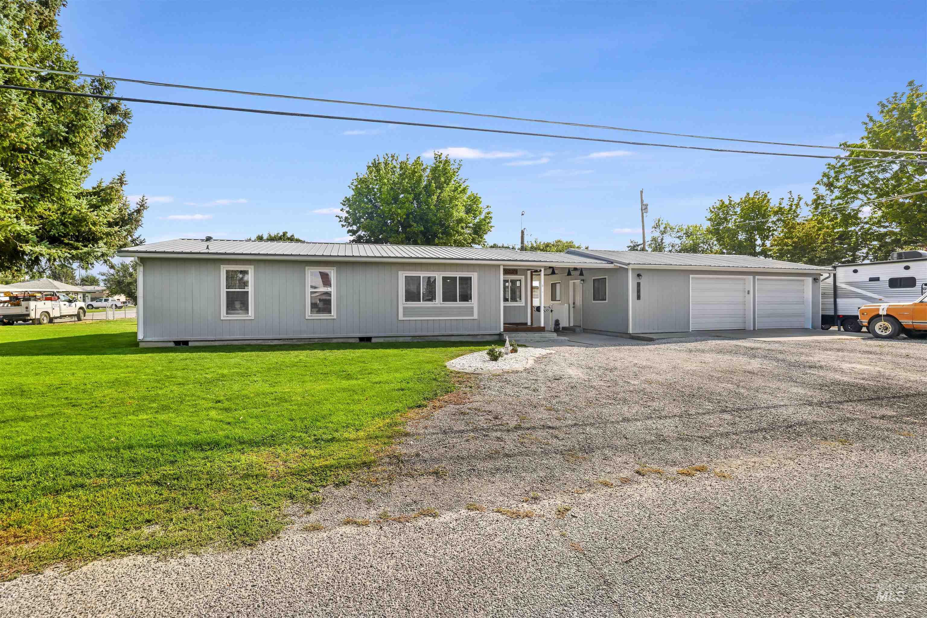Ranch-style house with a metal roof, driveway, crawl space, a front lawn, and a garage