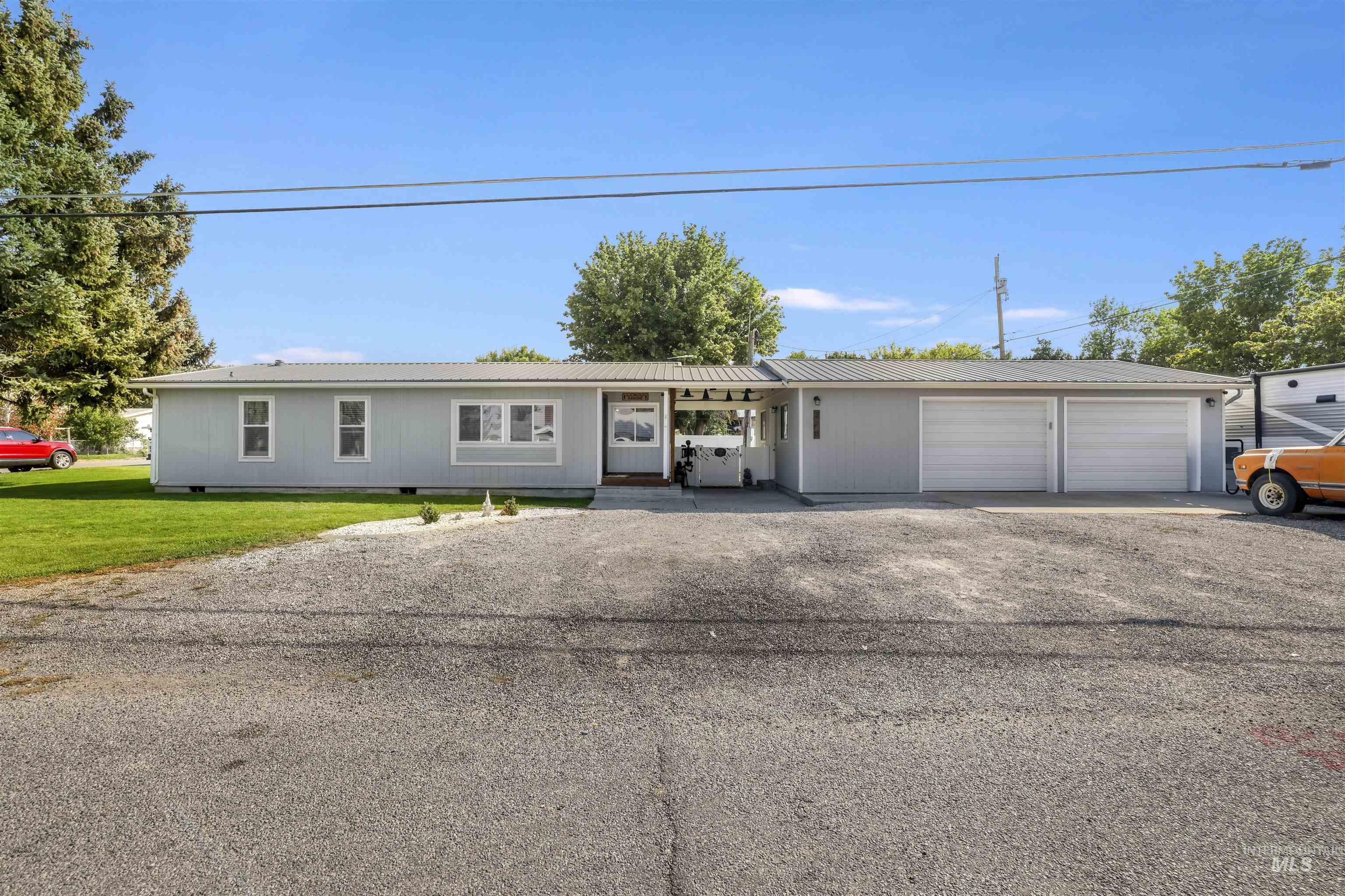 Ranch-style home featuring driveway, a front lawn, crawl space, and a metal roof