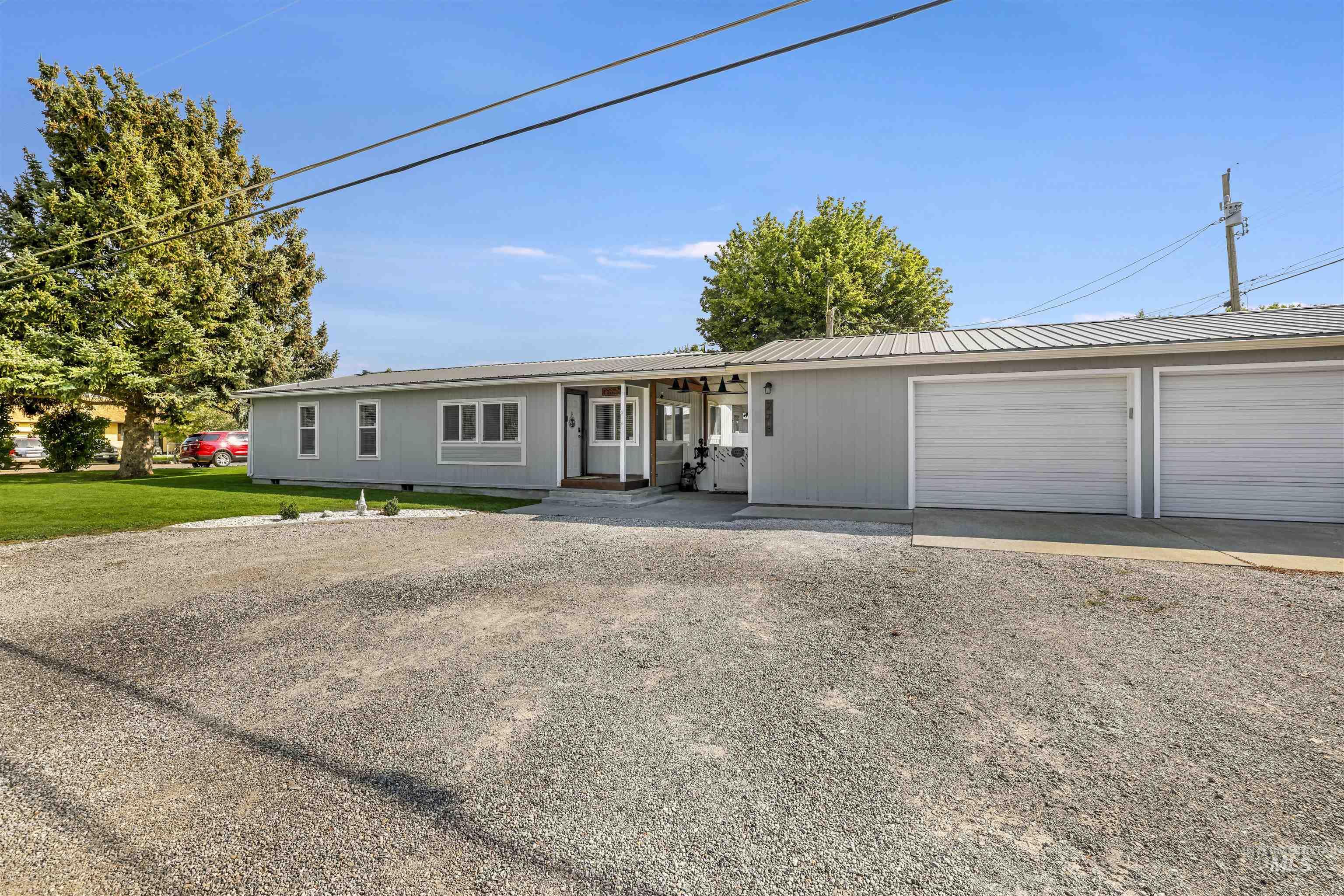 Ranch-style house featuring a metal roof, driveway, and a garage