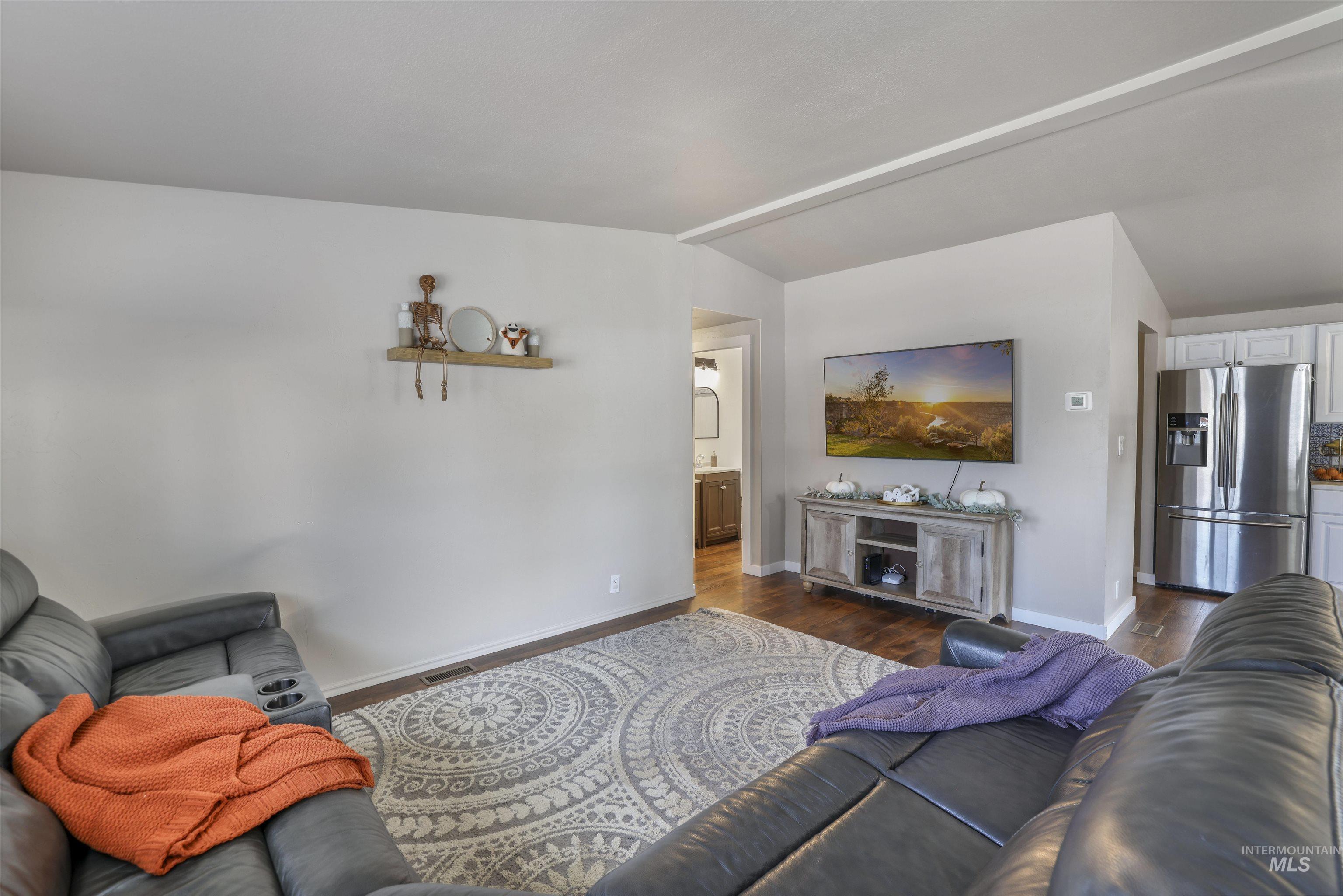 Living area featuring wood finished floors and vaulted ceiling