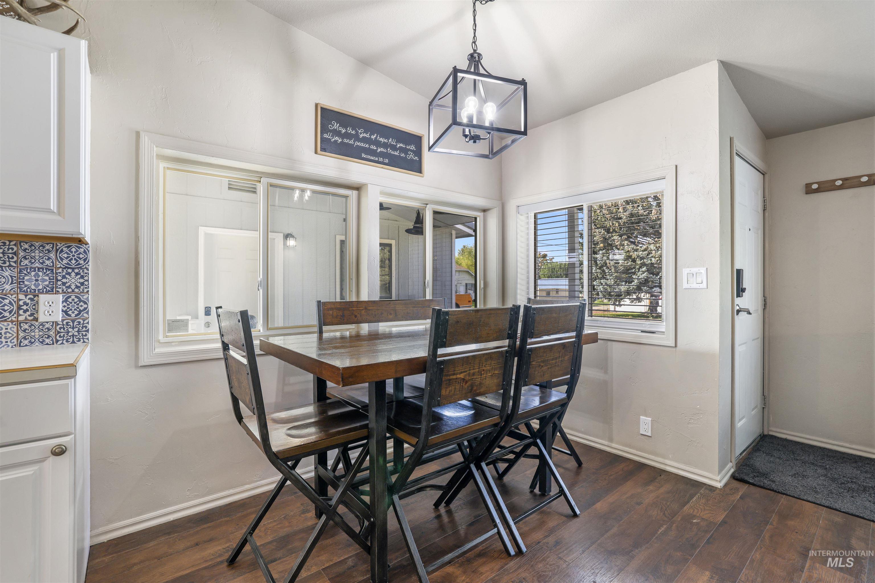 Dining area with a chandelier and dark wood finished floors