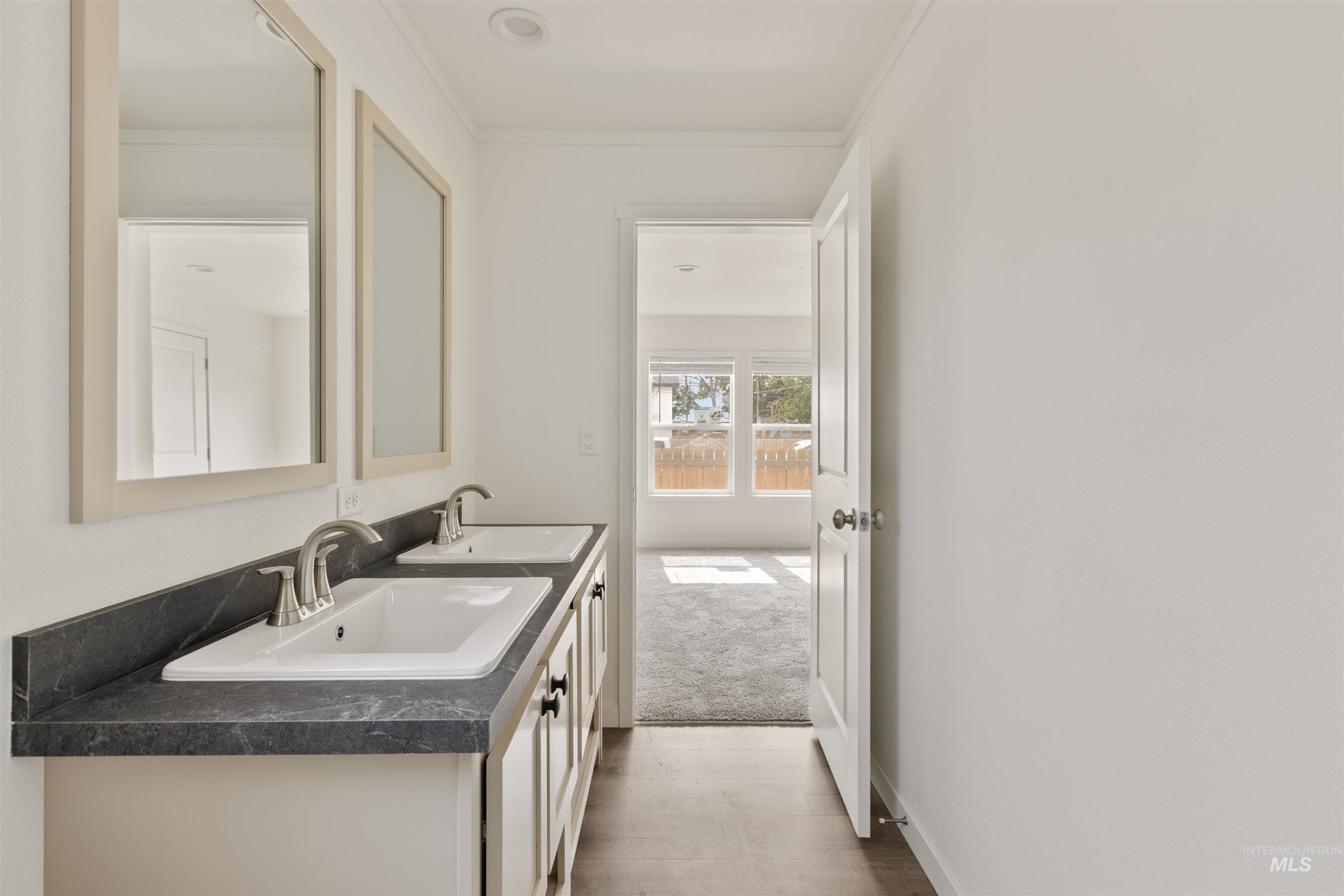 Bathroom featuring ornamental molding and double vanity