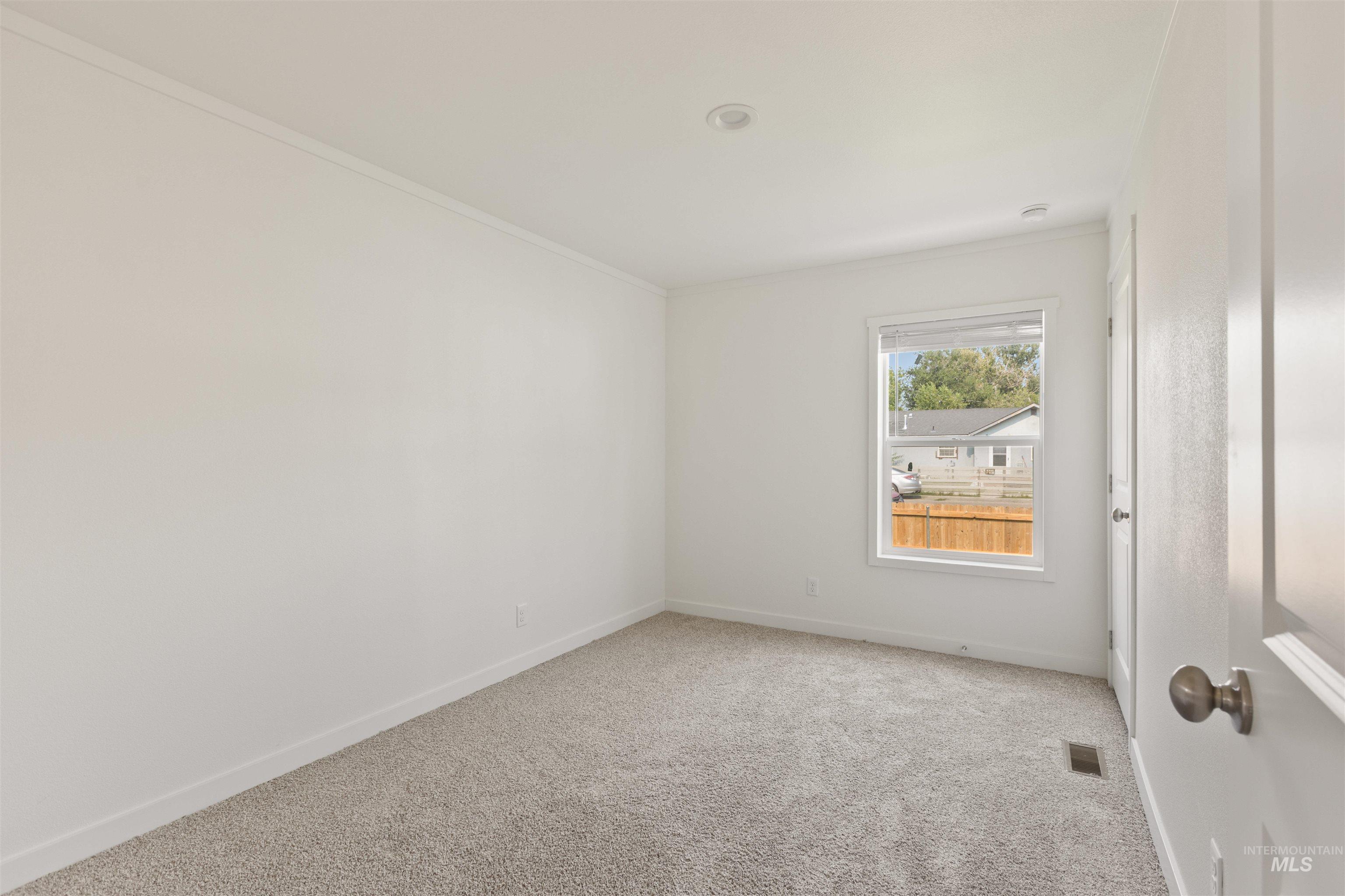 Carpeted spare room featuring baseboards and ornamental molding