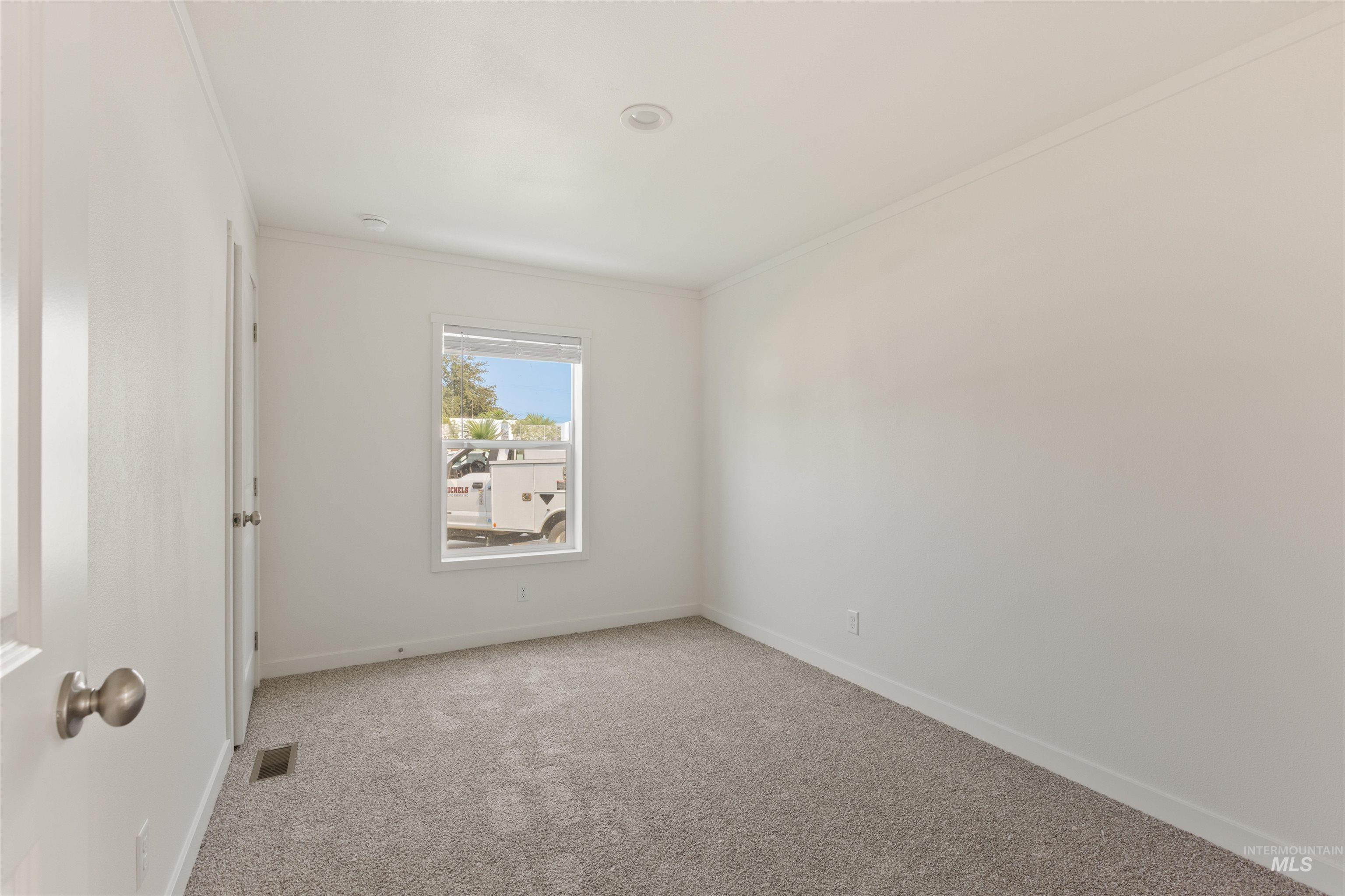 Unfurnished room featuring light colored carpet and crown molding