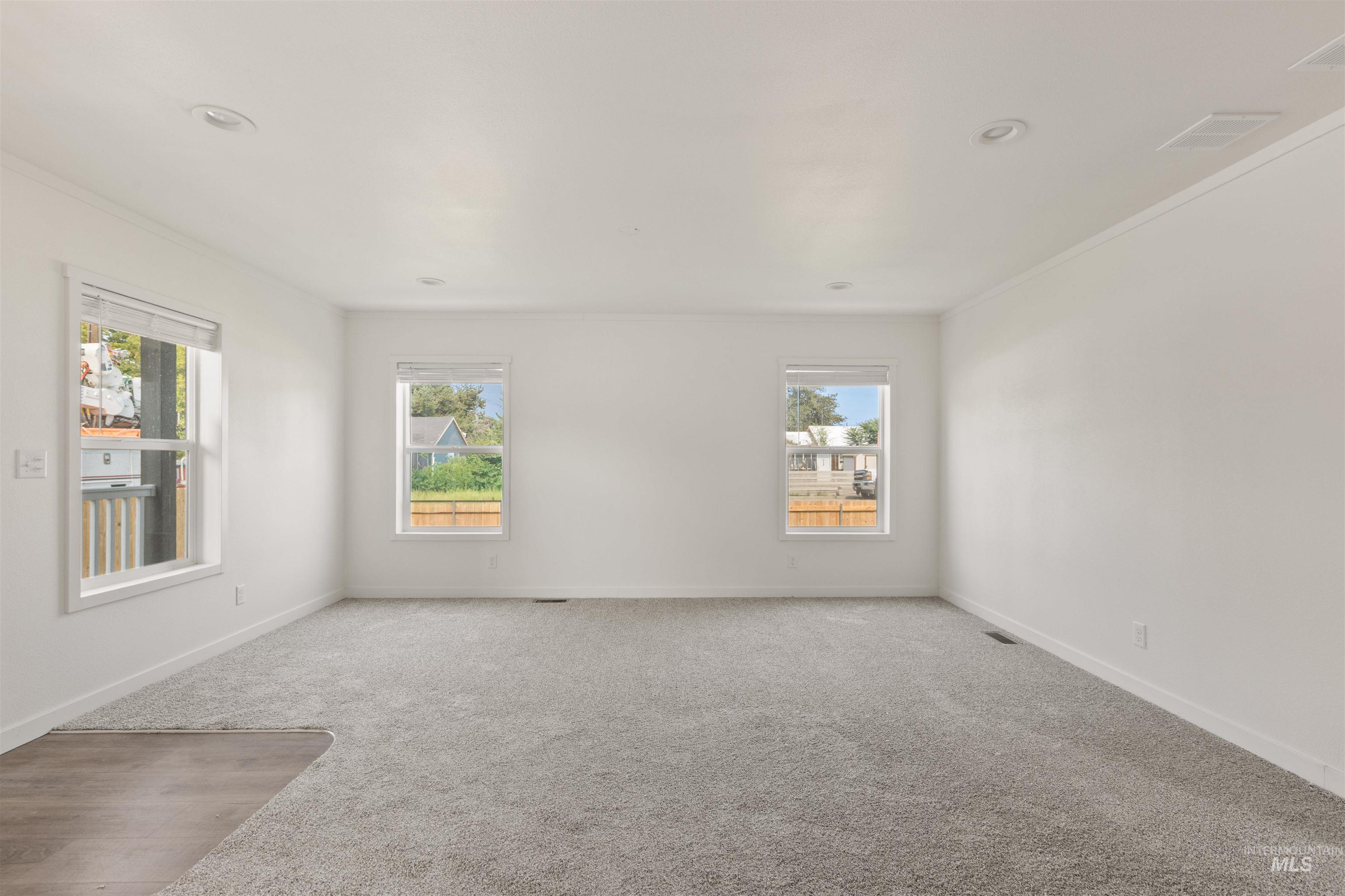 Empty room with carpet floors and crown molding